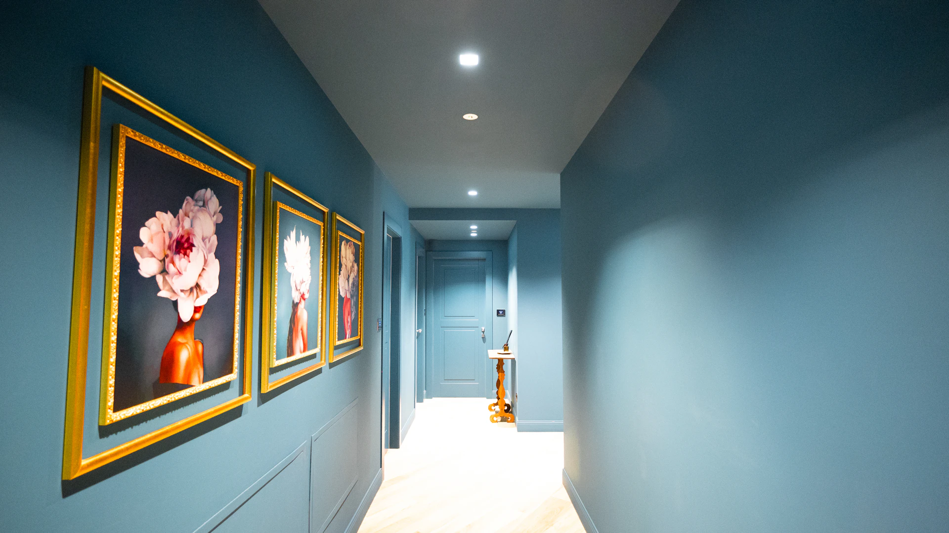 Hallway painted blue with framed artwork
