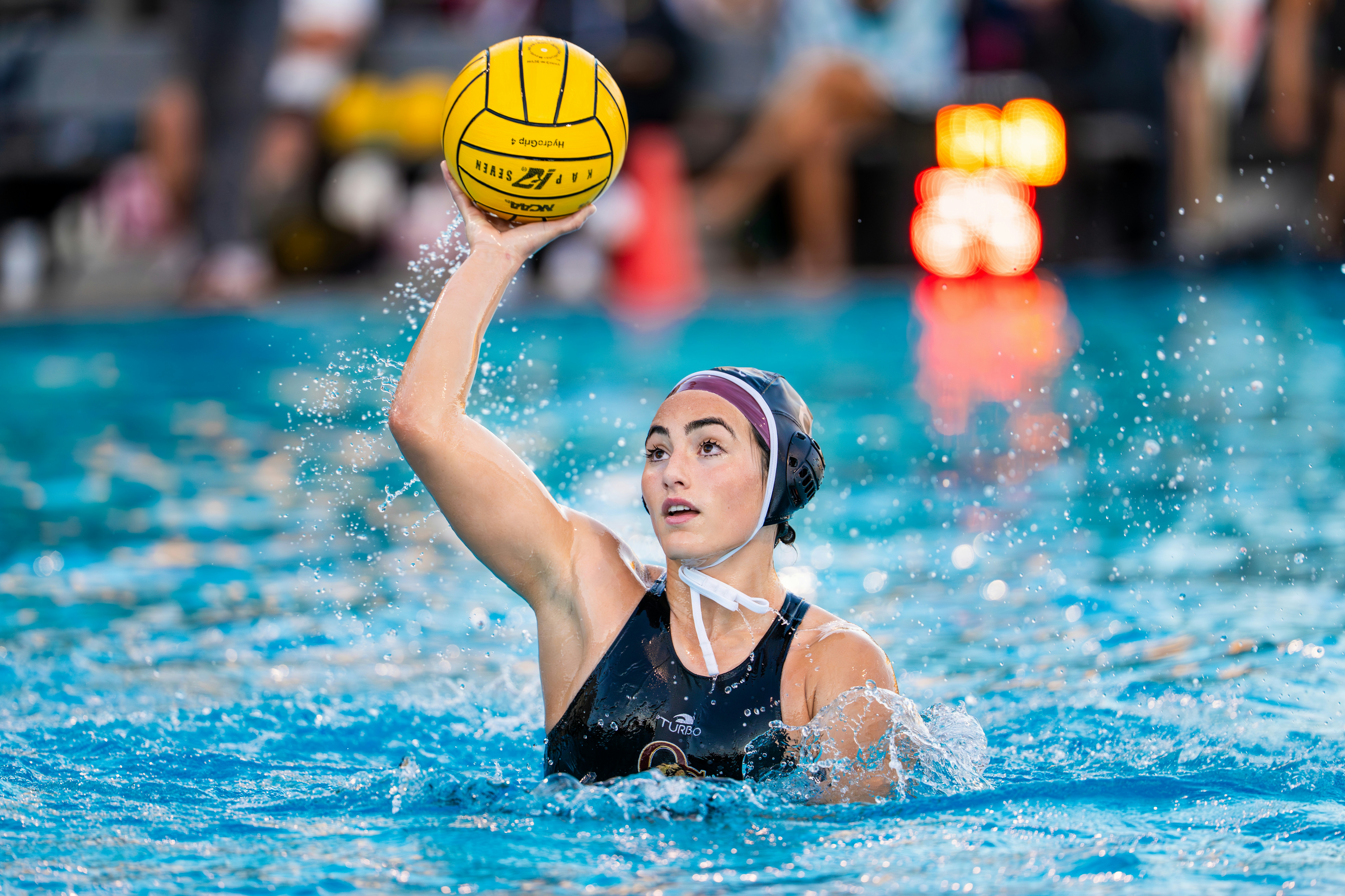 Female water polo player with ball in water