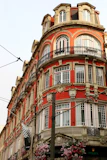 Ornate red building with balconies and windows.