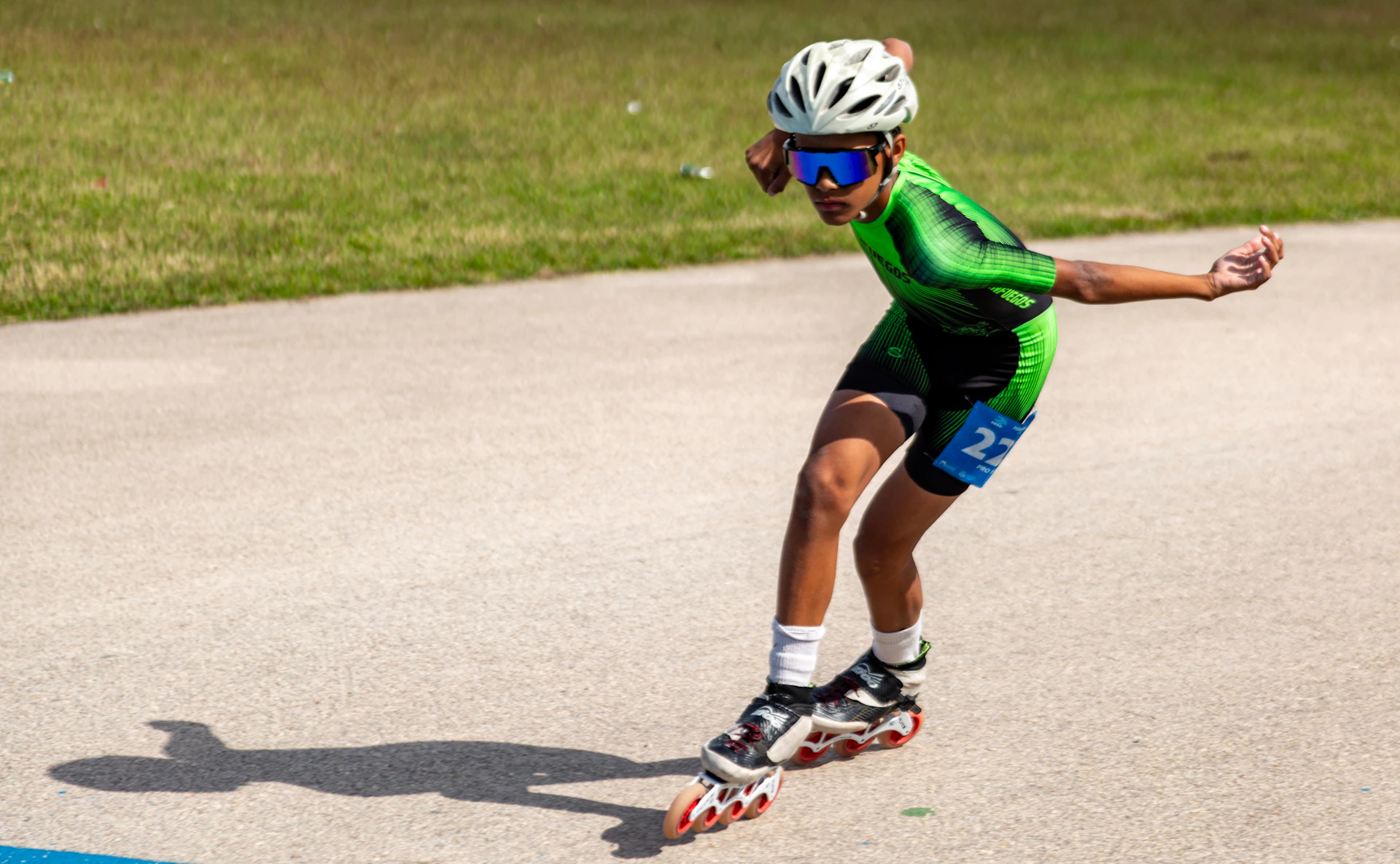 A person in helmet and goggles rollerblading on a path.