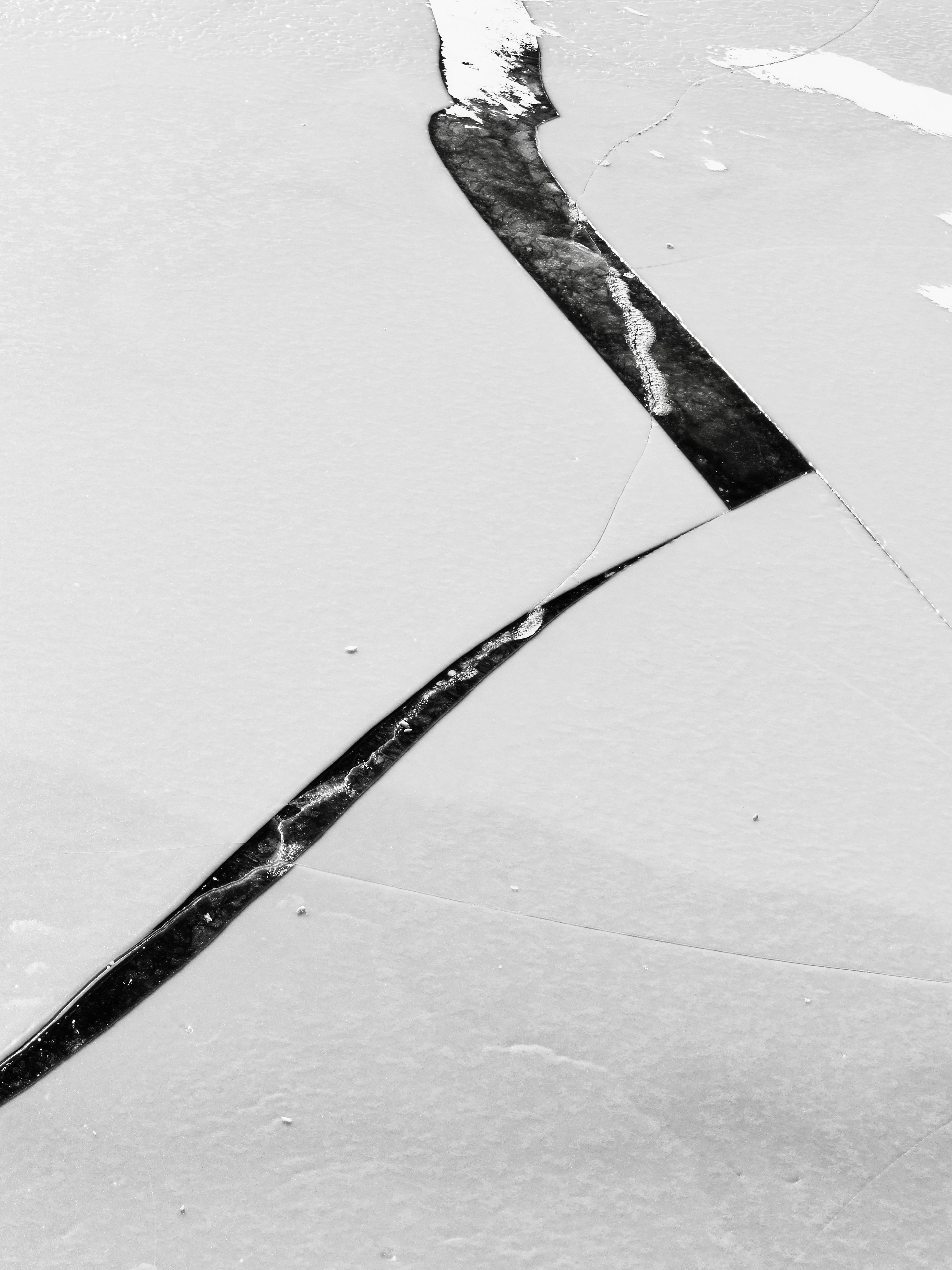 Cracked ice surface with dark fissures.