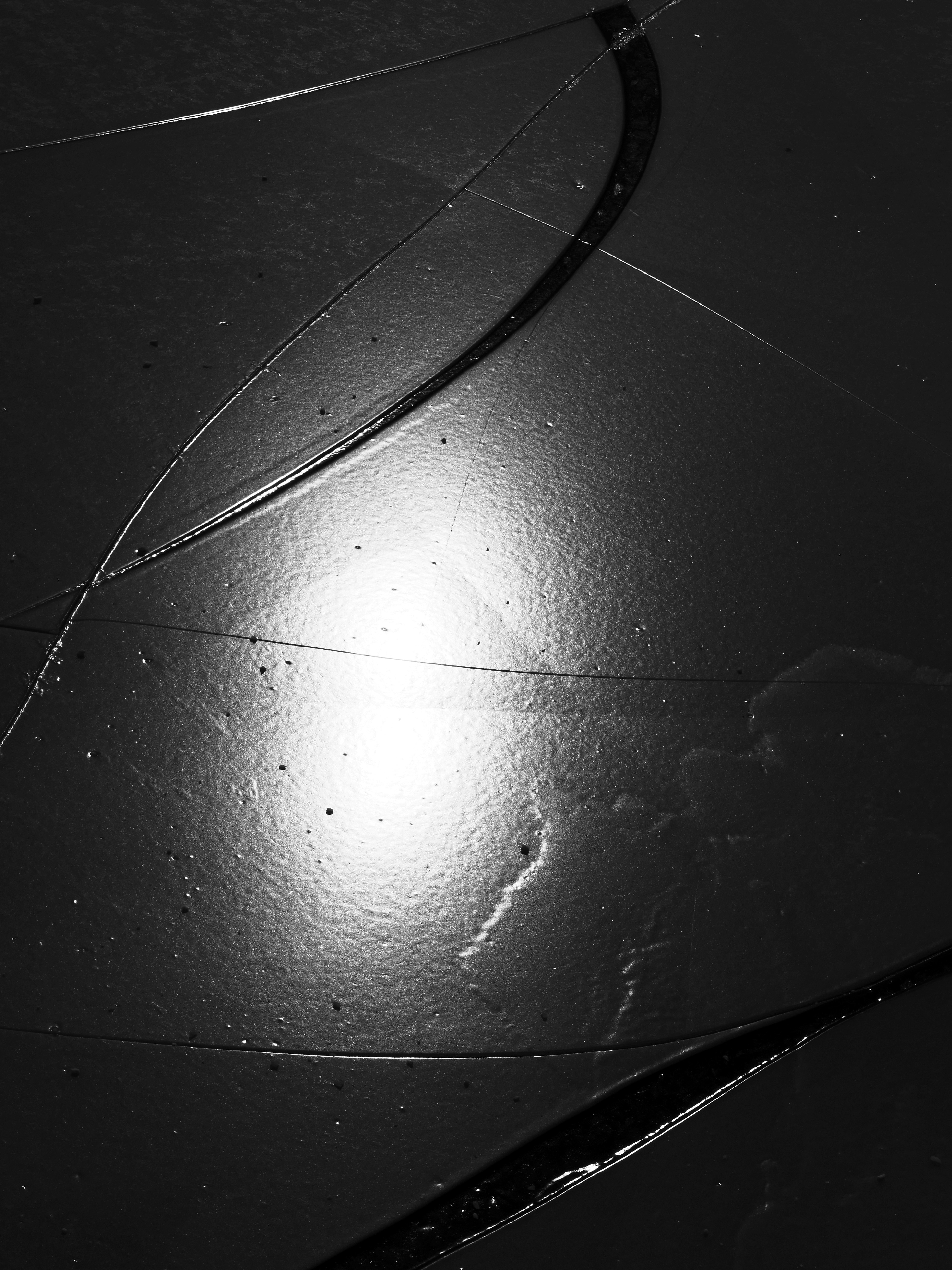 Cracked dark surface with a bright light reflection