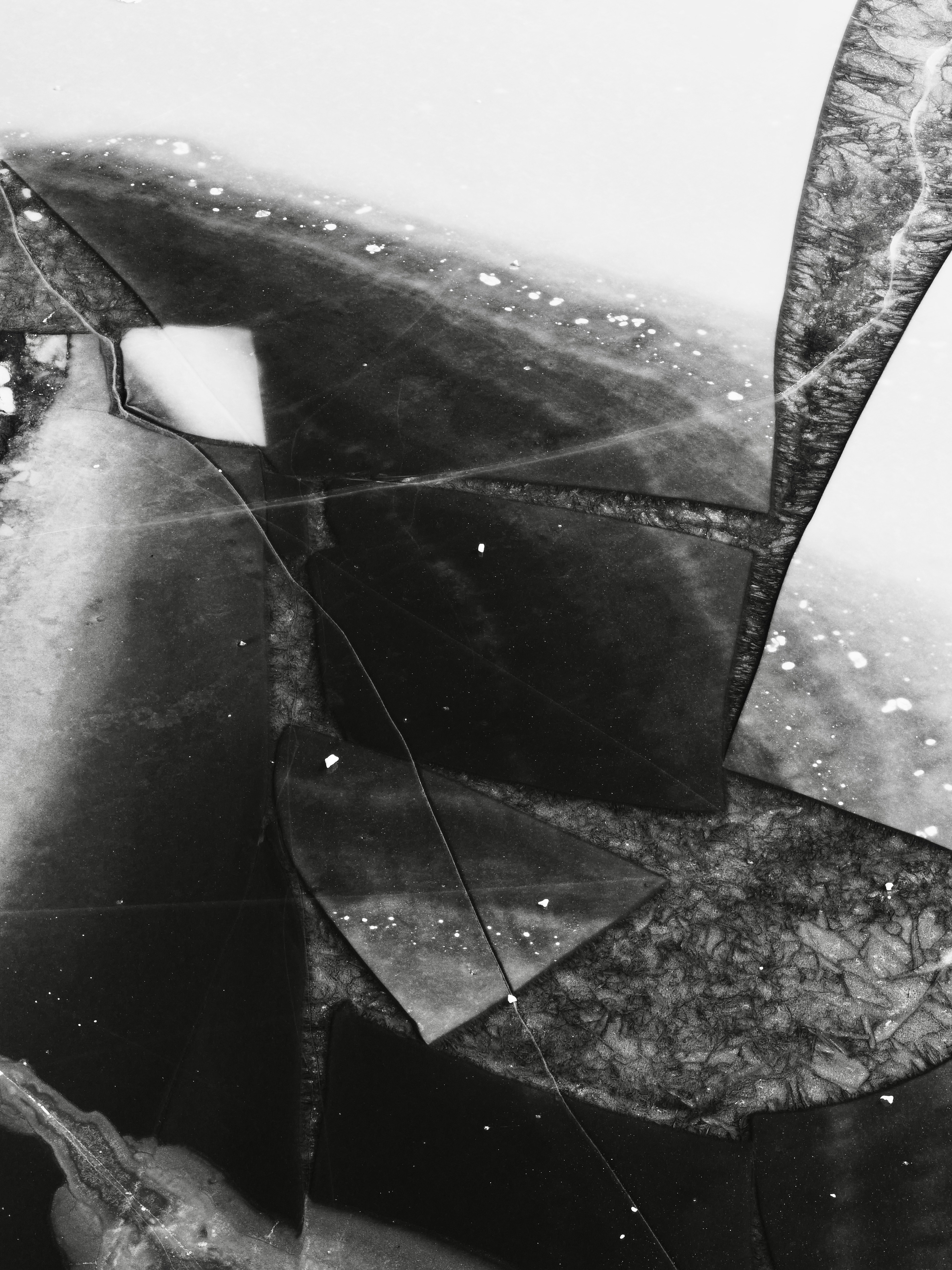 Abstract pattern of cracked ice on a frozen surface.