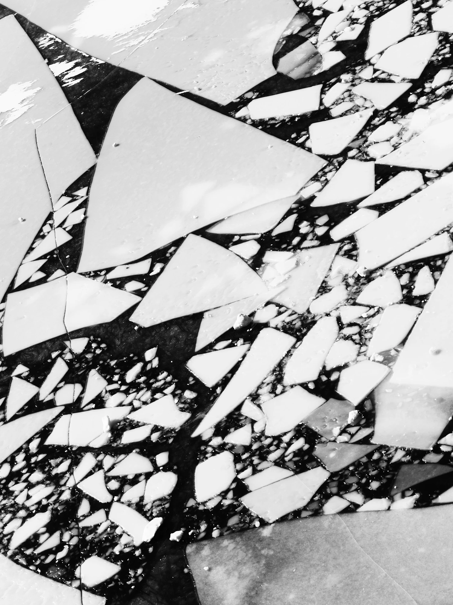 Angular white fragments of a shattered sheet against black