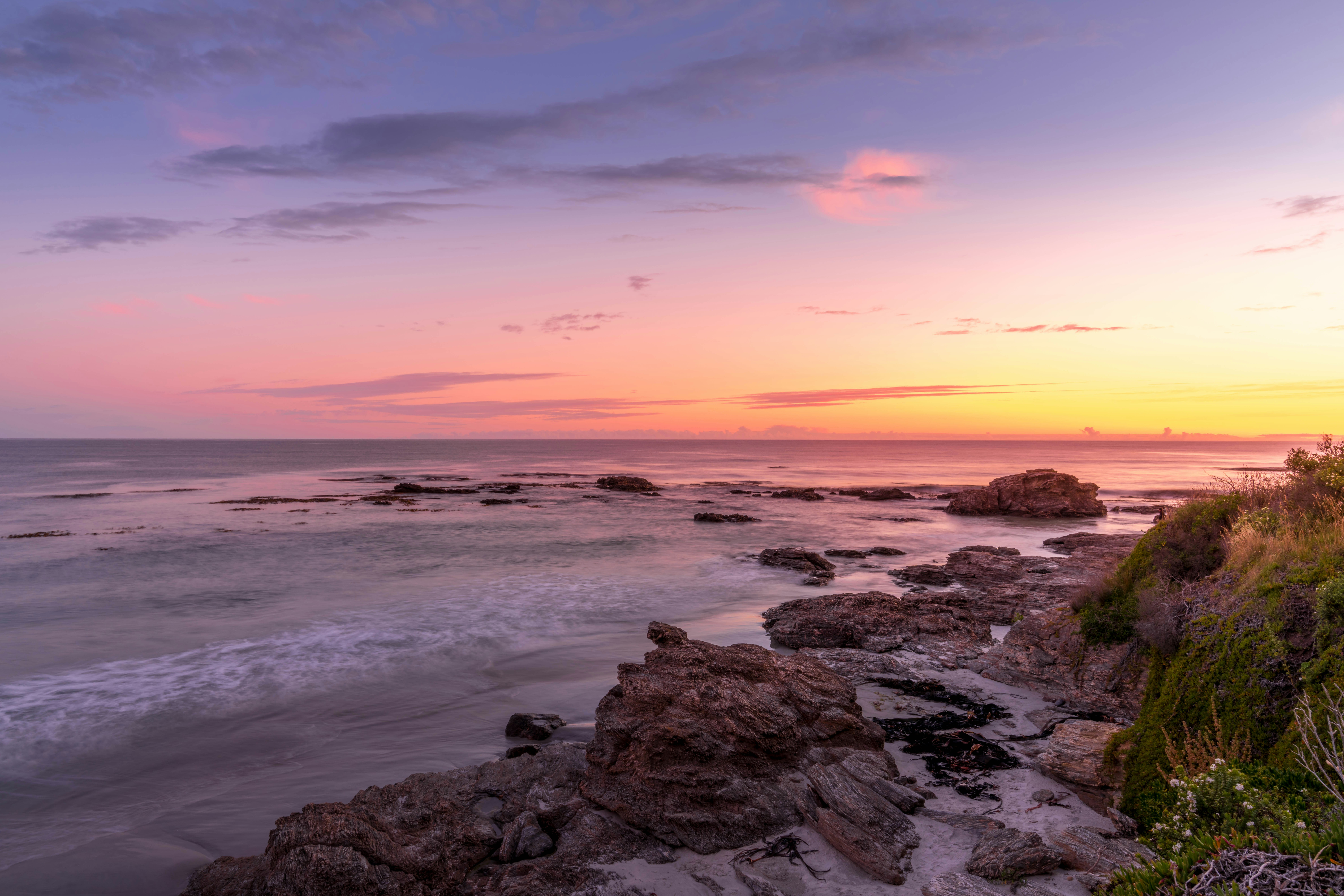 Ocean waves crash on rocky shore at sunset