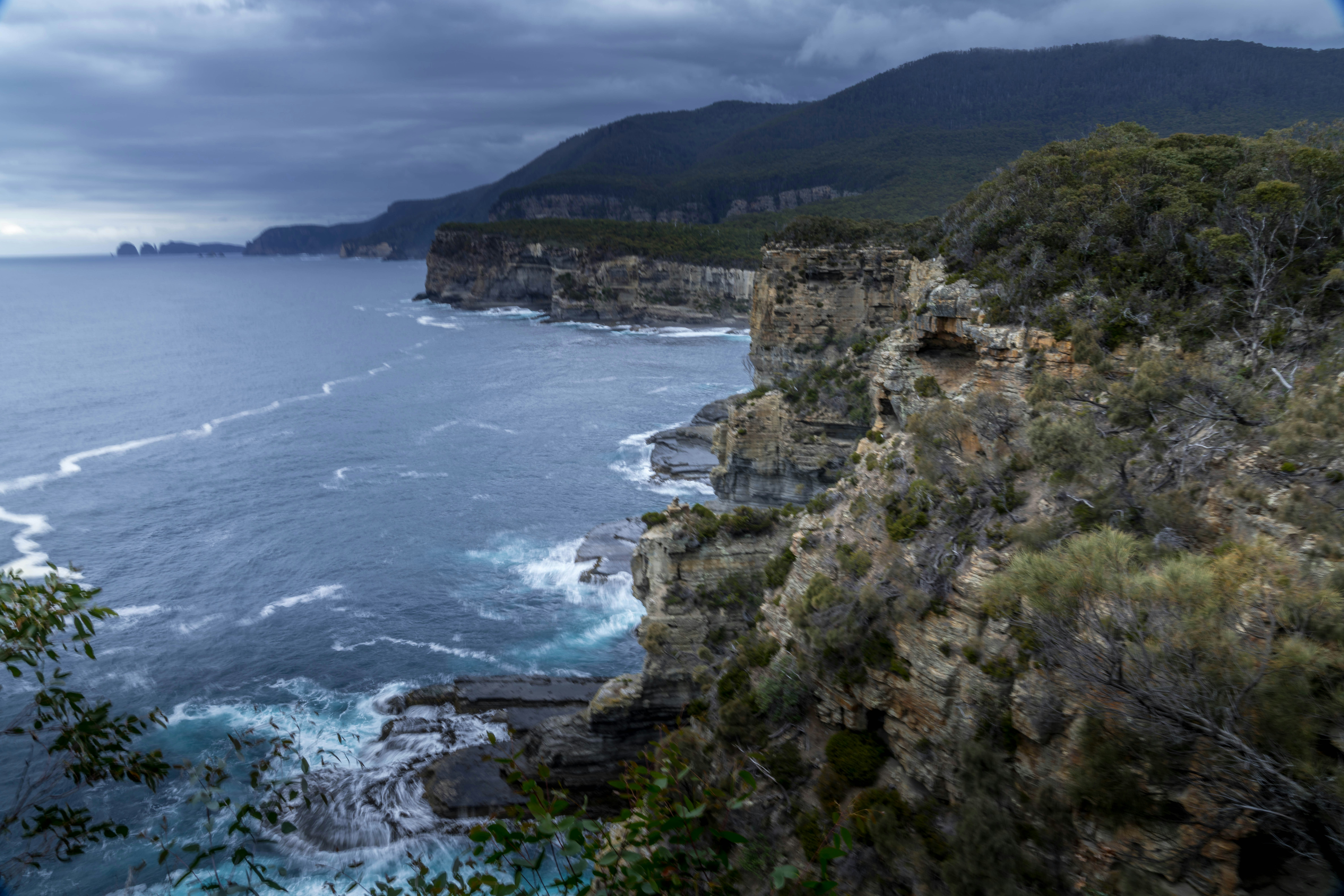 Rugged coastline with choppy ocean waves under cloudy sky
