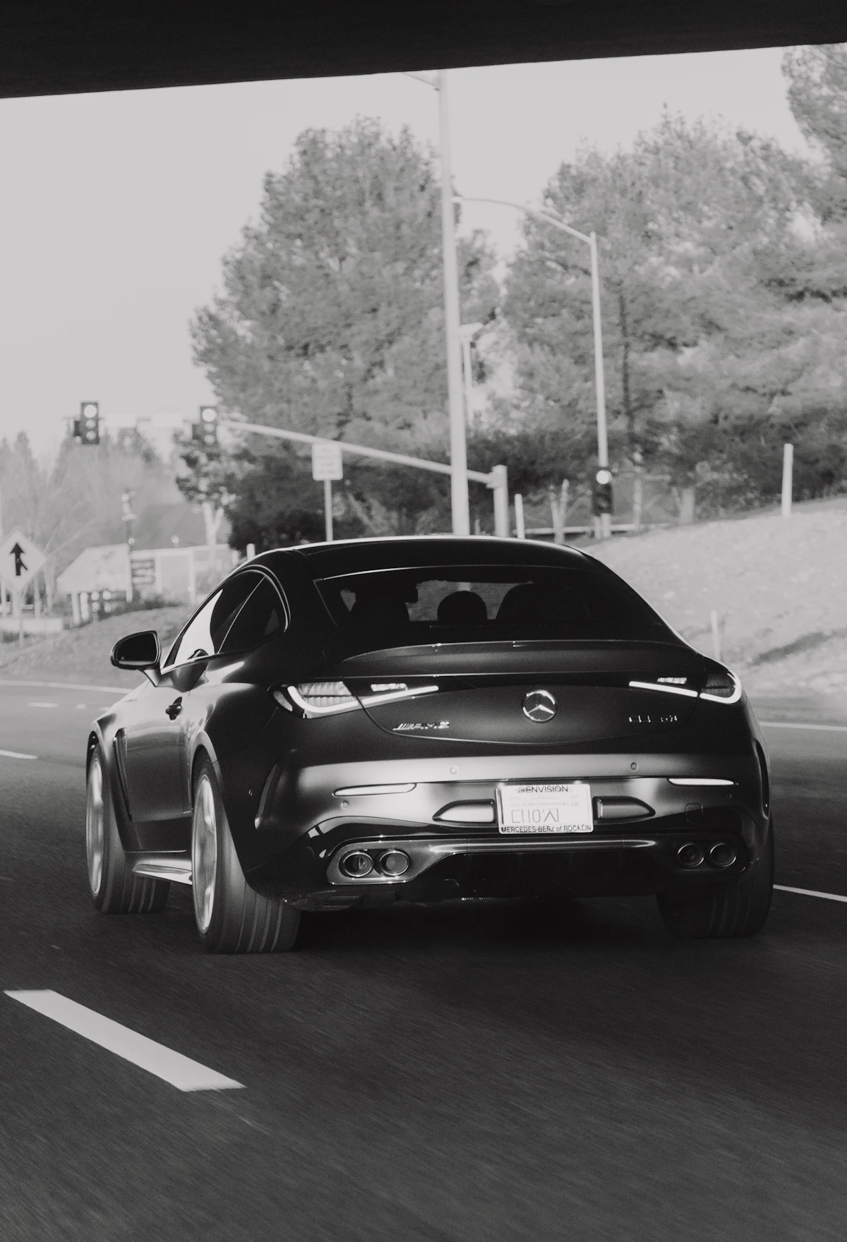 Black luxury car driving on a highway