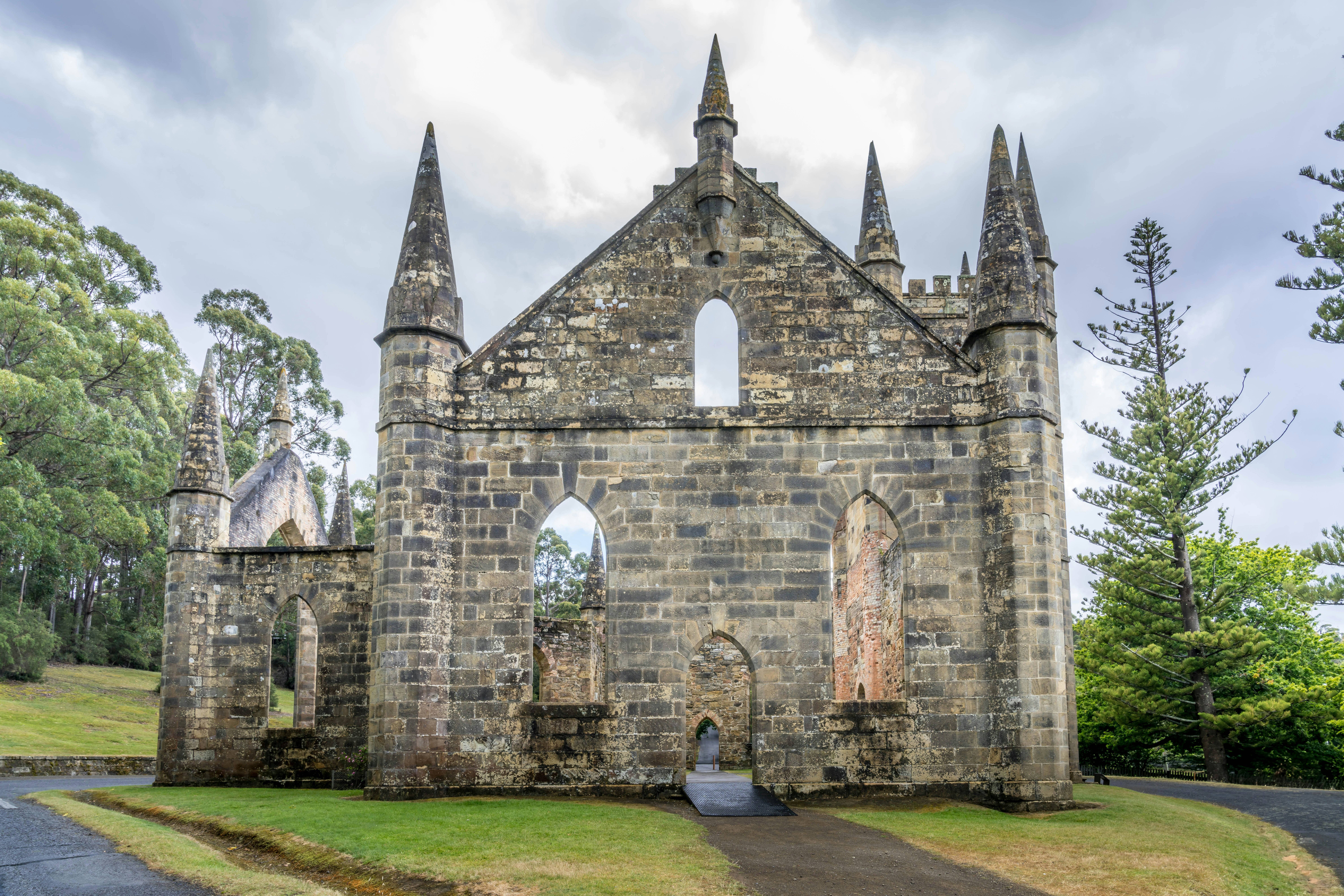 Iglesia de piedra en ruinas con arquitectura gótica y árboles