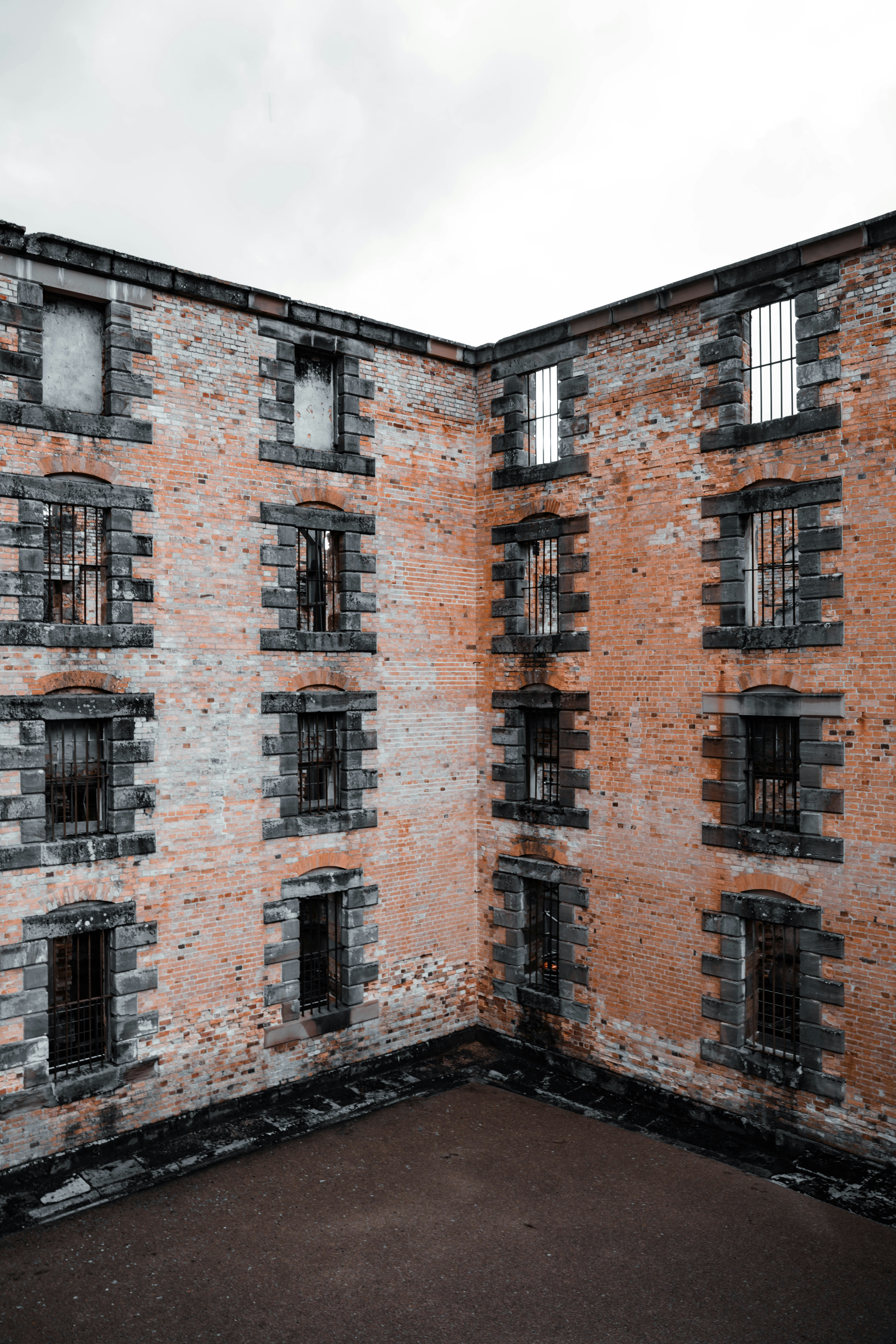 Edificio abandonado de ladrillo con ventanas enrejadas y patio