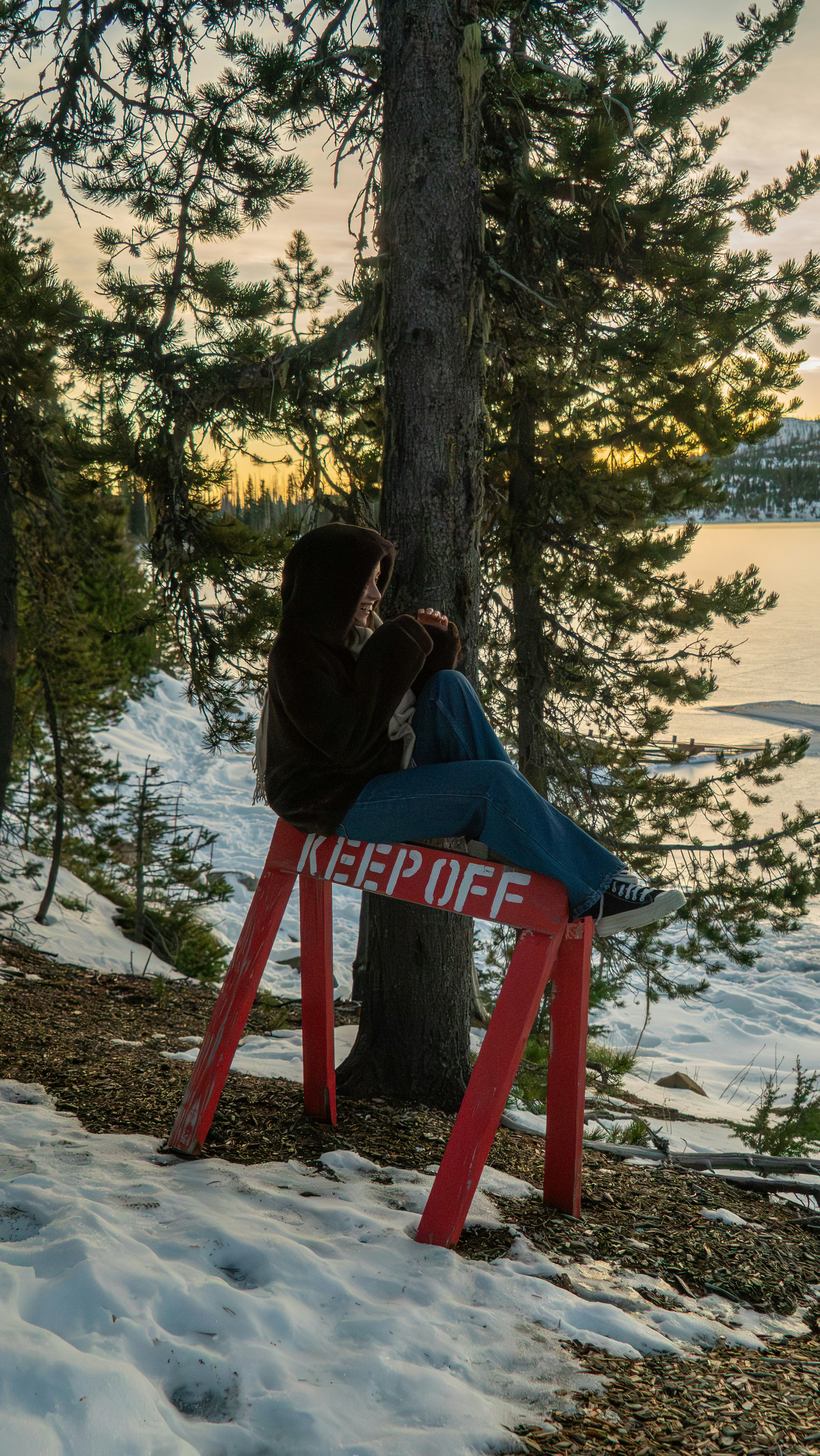 パーカーを着た人が赤いバリケードに座っています。