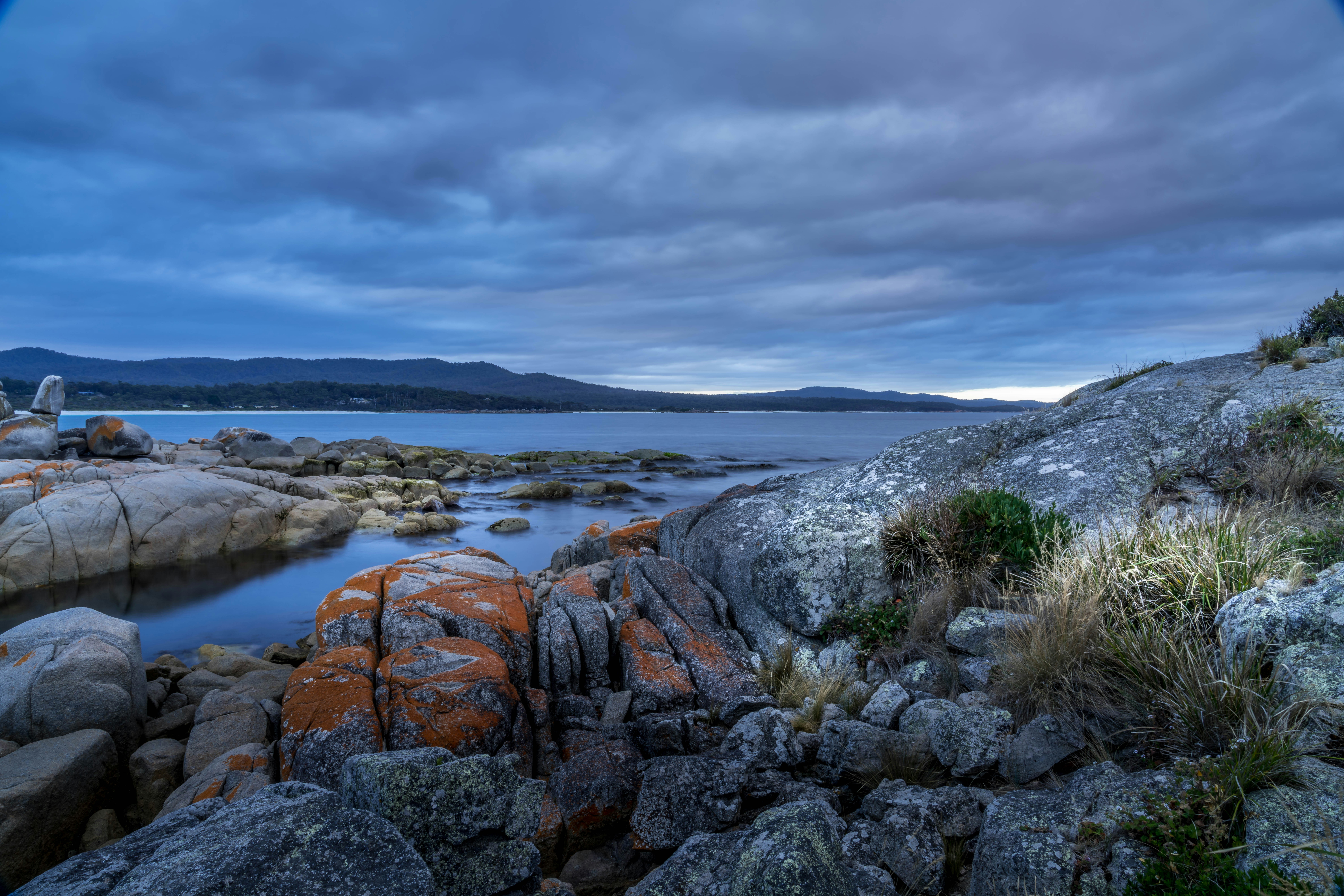 Costa rocosa con agua tranquila bajo cielo nublado