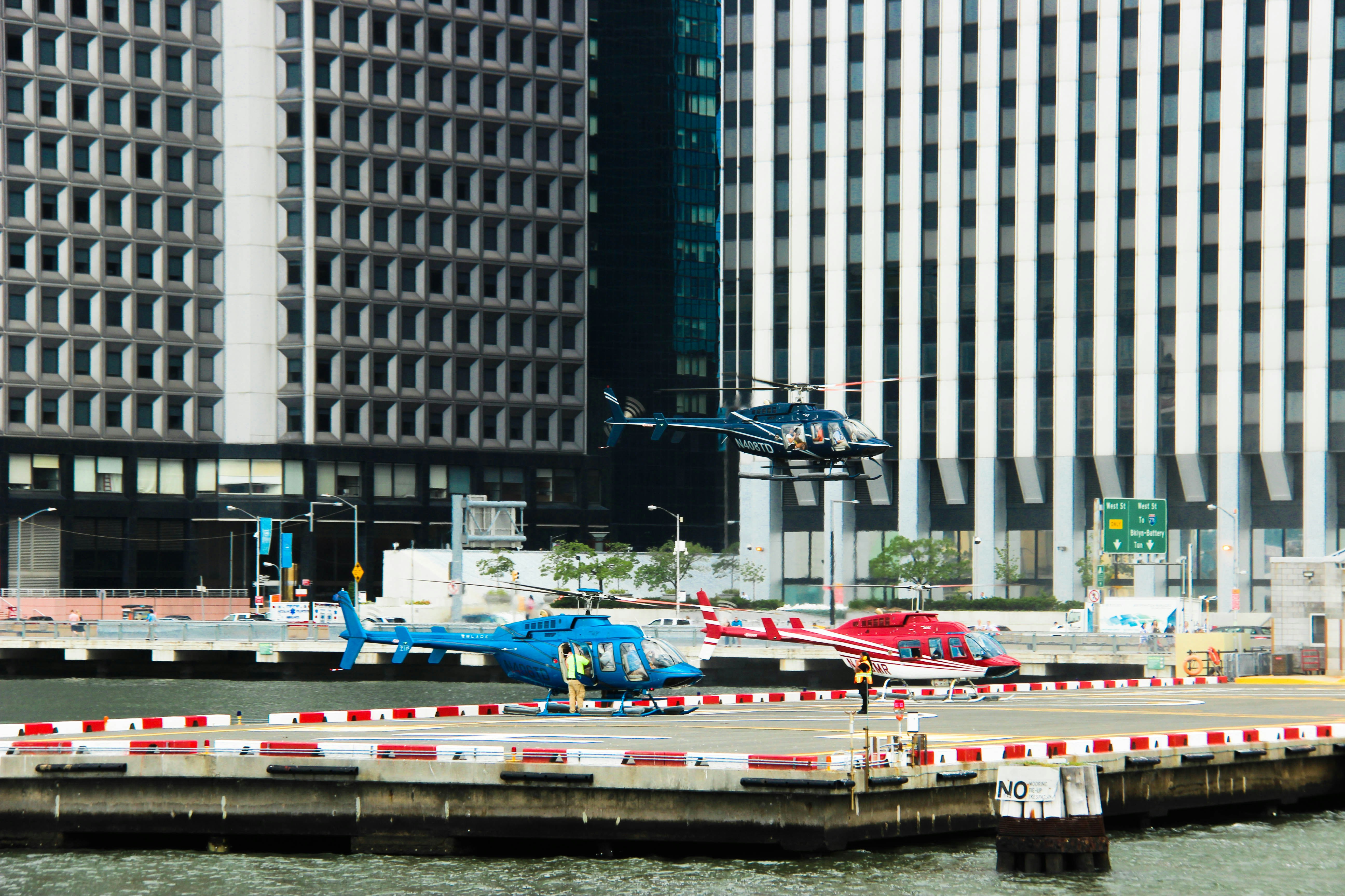 Two helicopters on a helipad near buildings