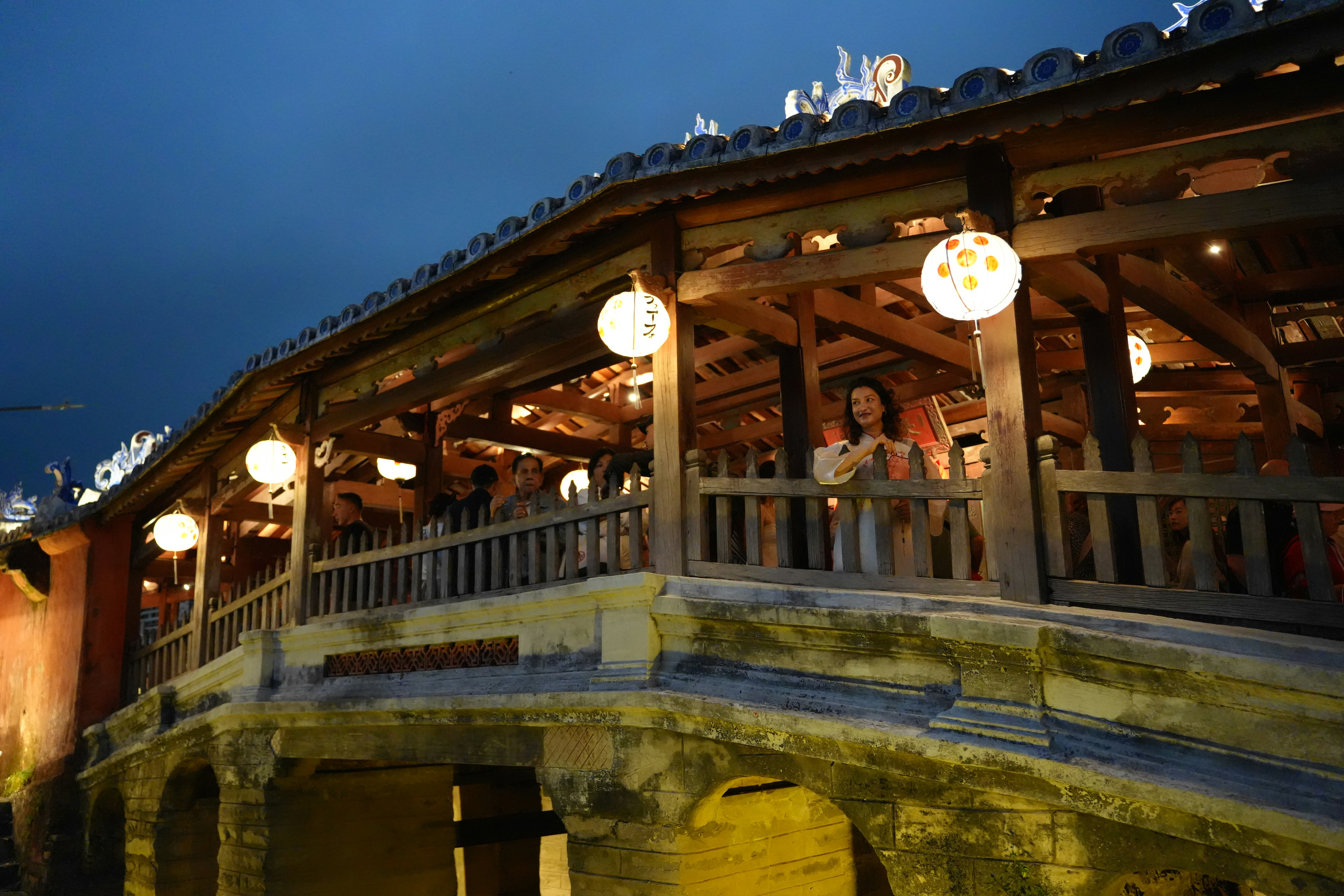 Covered wooden bridge with lanterns at dusk