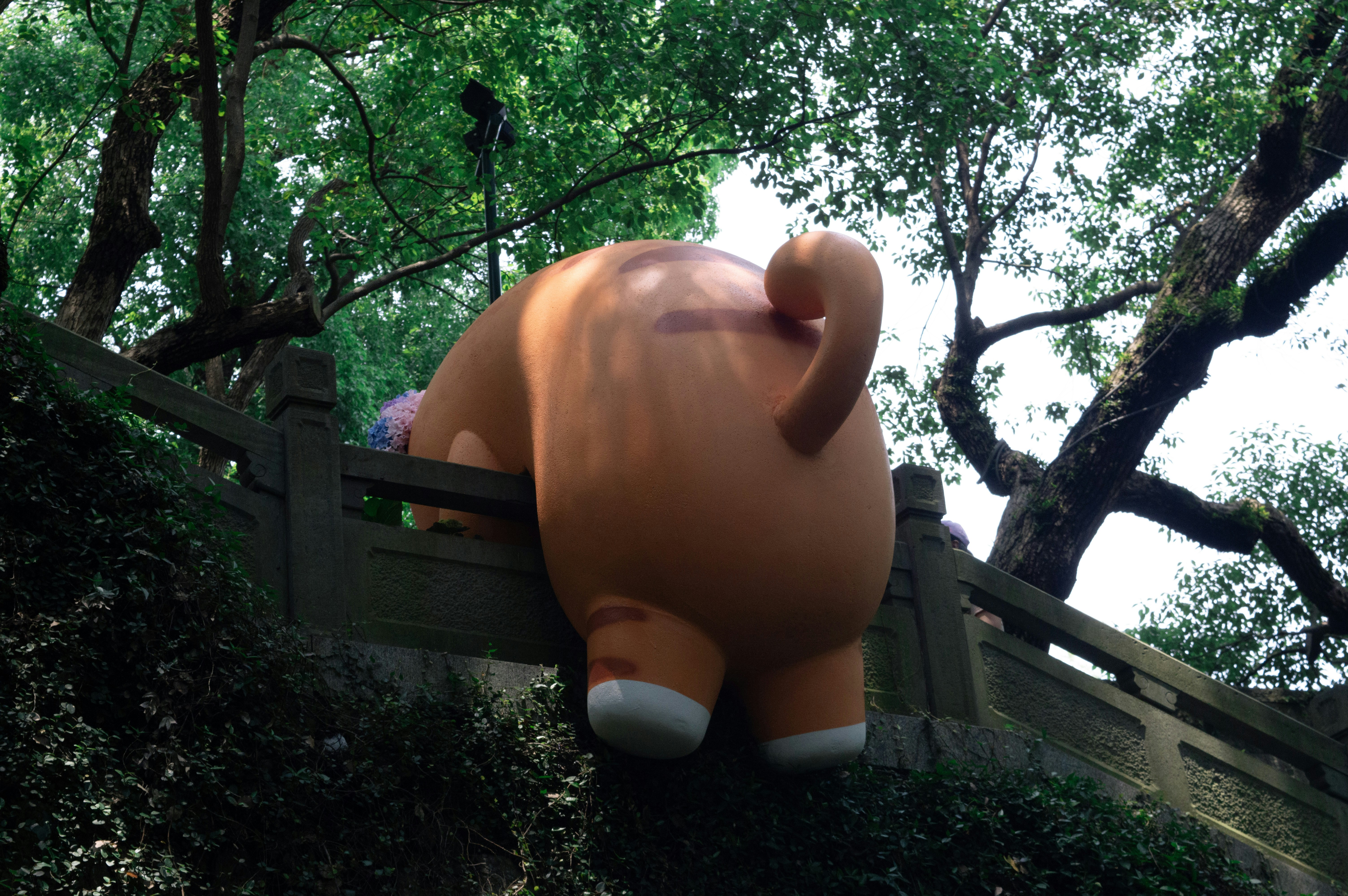 Large orange stuffed animal peeking over wall