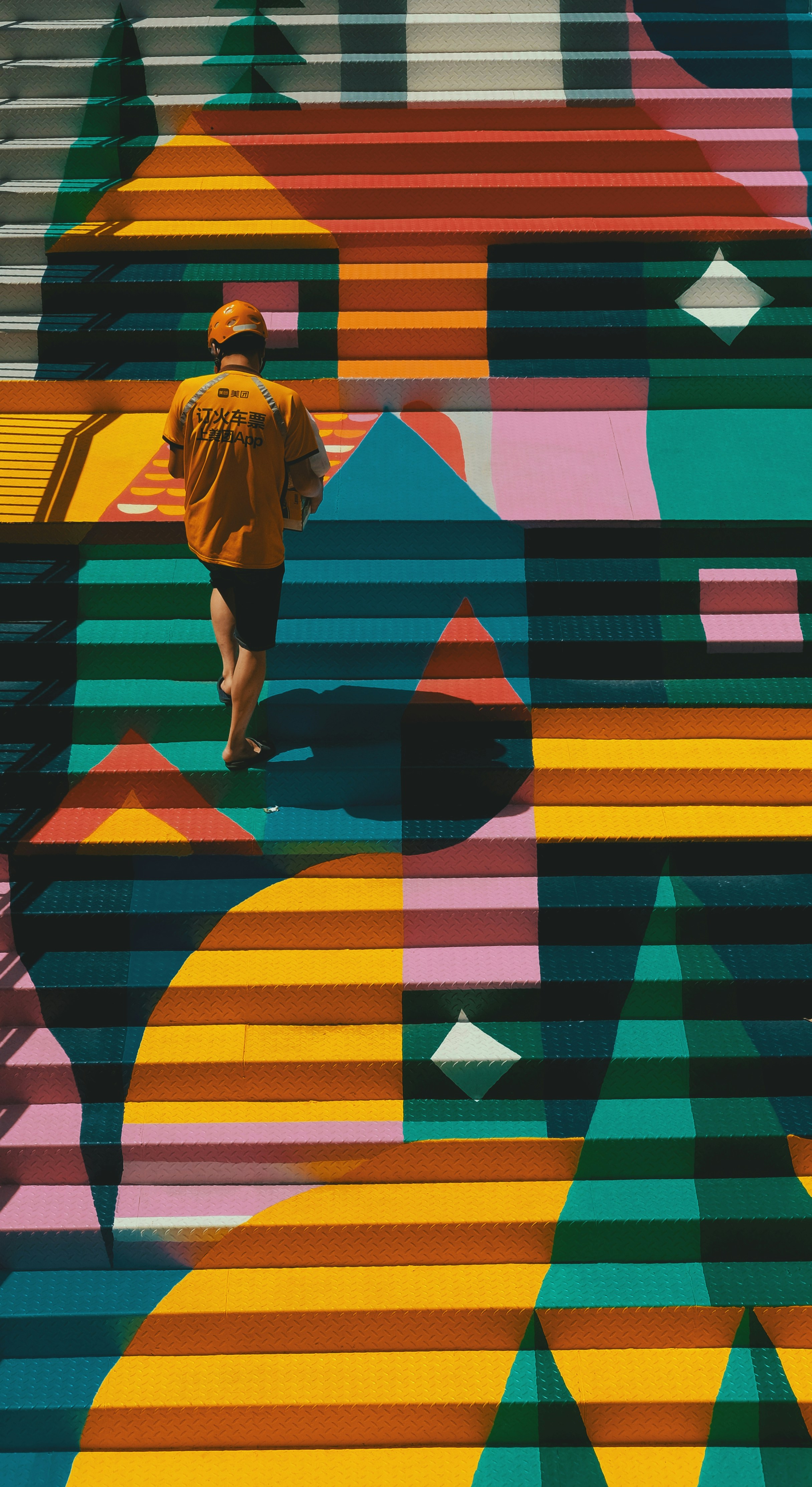 Person walking on colorful geometric stairs