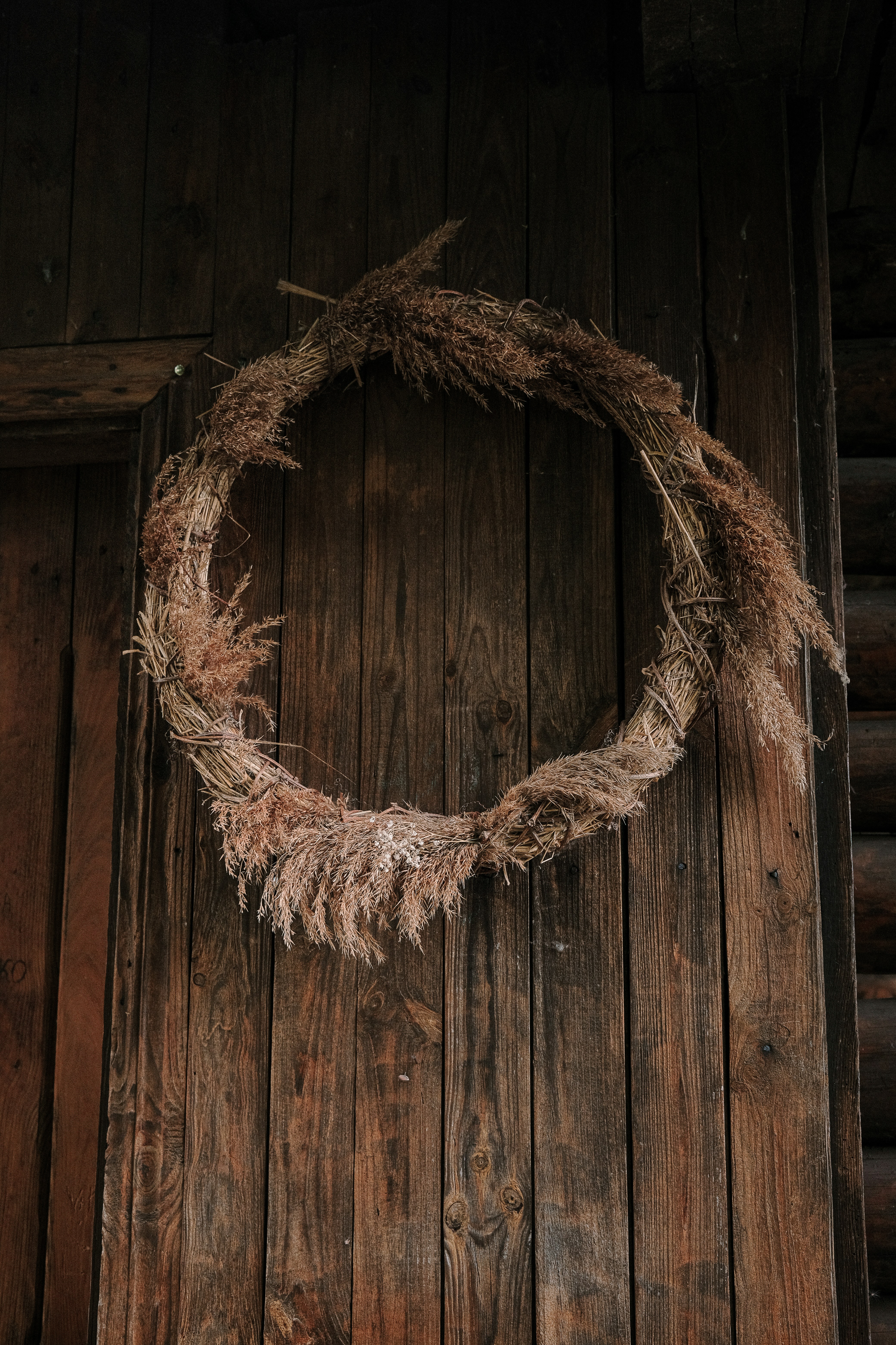Dried grass wreath hanging on a wooden door