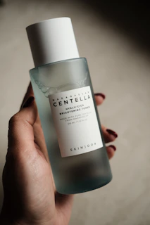 Hand holding a bottle of centella brightening toner