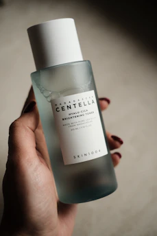 Hand holding a bottle of centella brightening toner