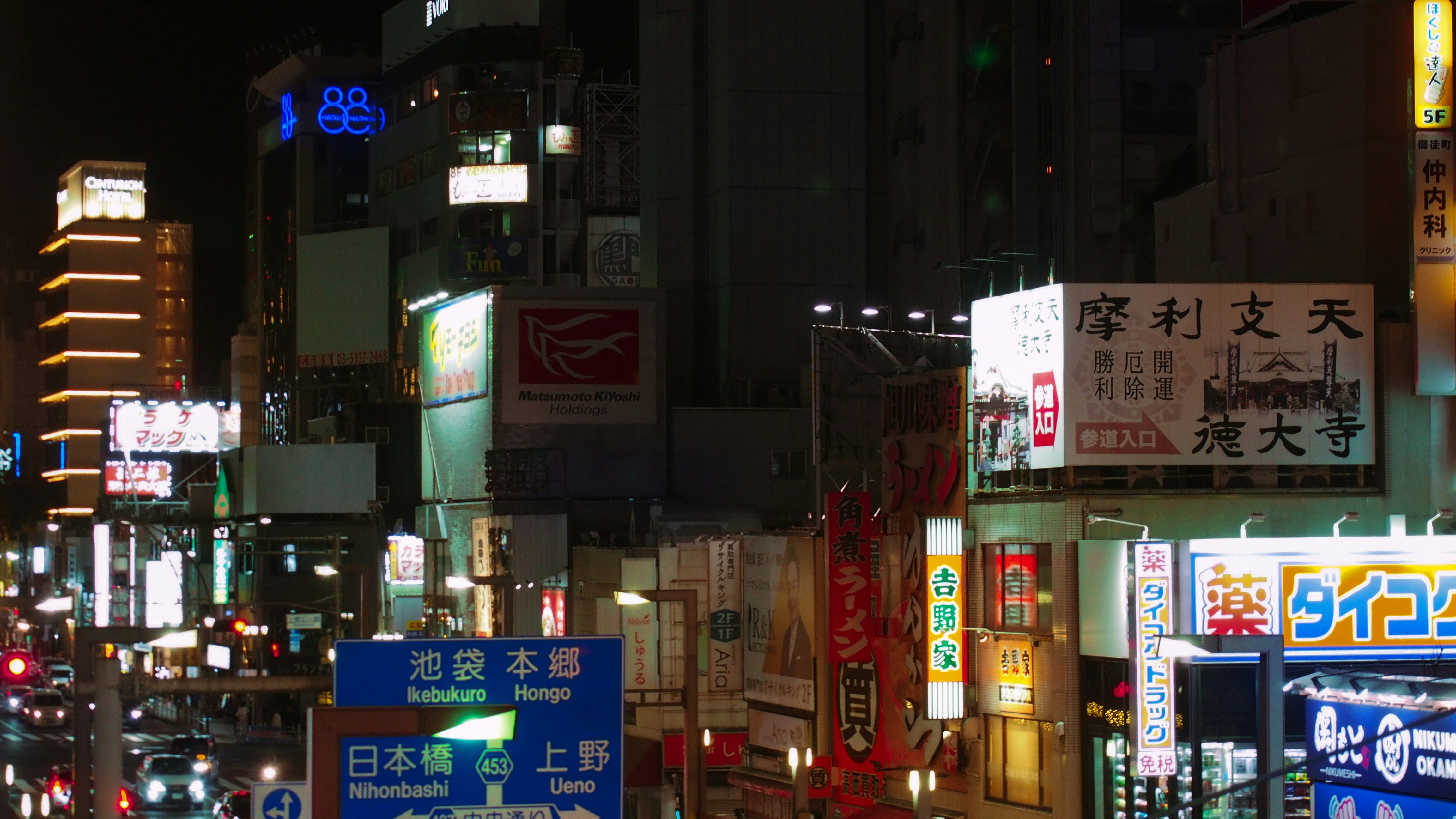 A vibrant cityscape at night with many illuminated signs.