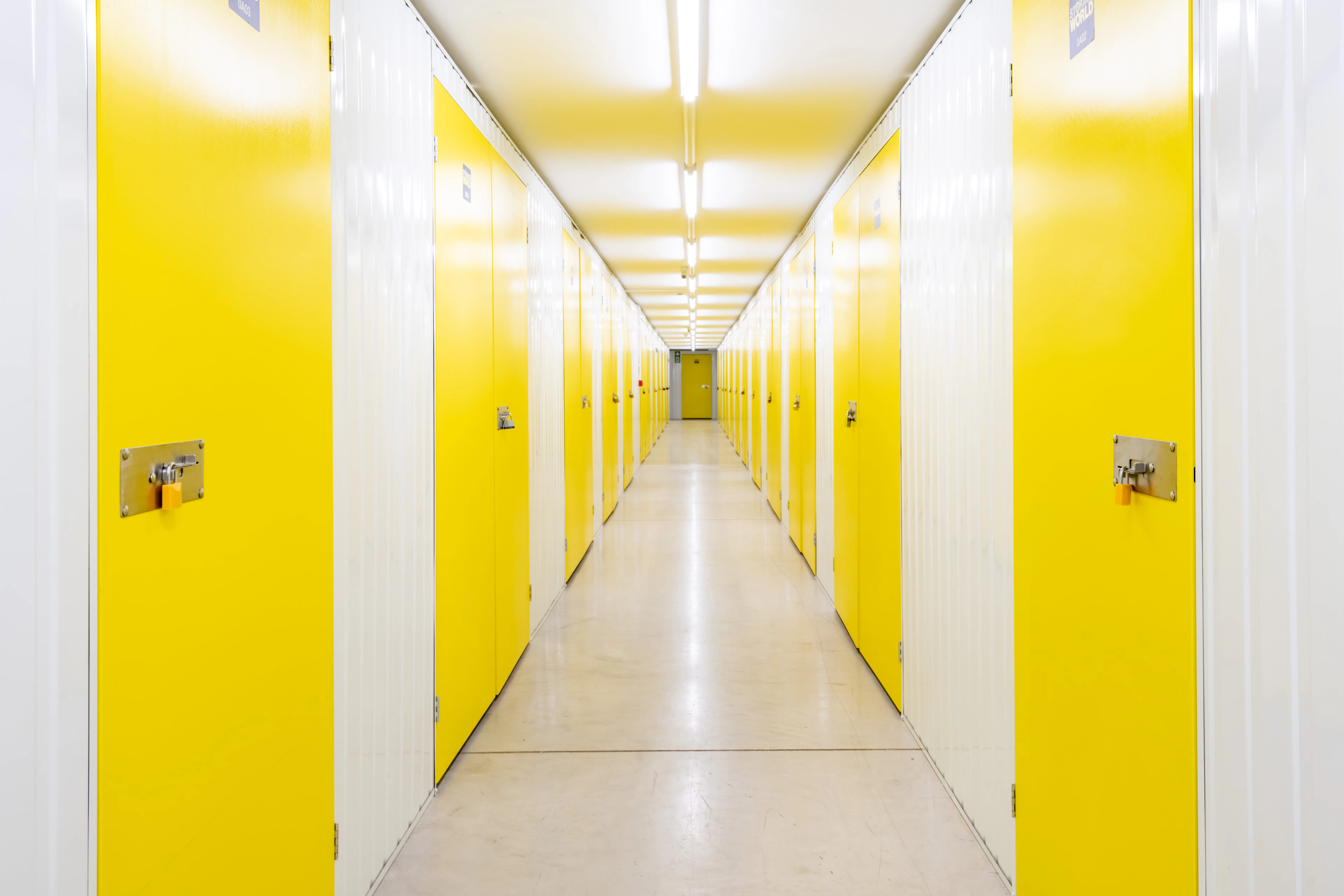 A modern, brightly lit self-storage facility corridor