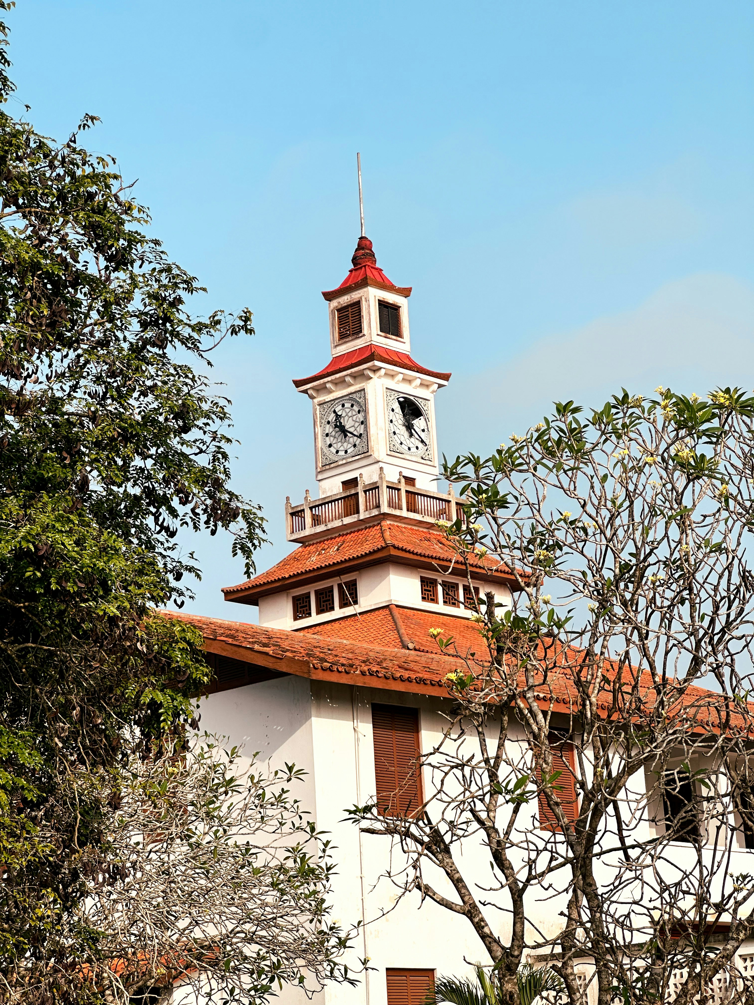 Bâtiment blanc au toit rouge et à la tour de l’horloge