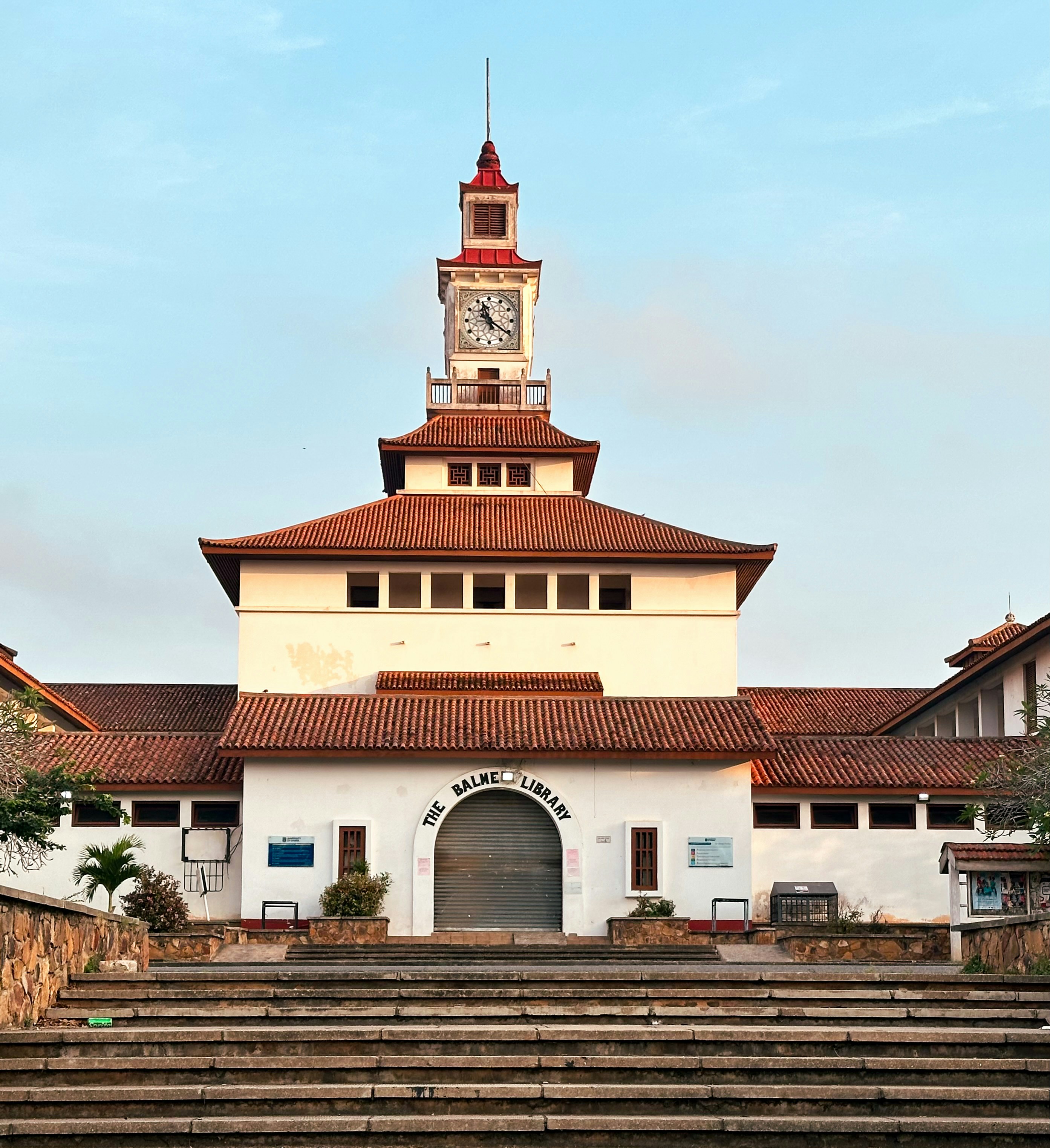 Bâtiment historique avec une tour d’horloge et un toit rouge.