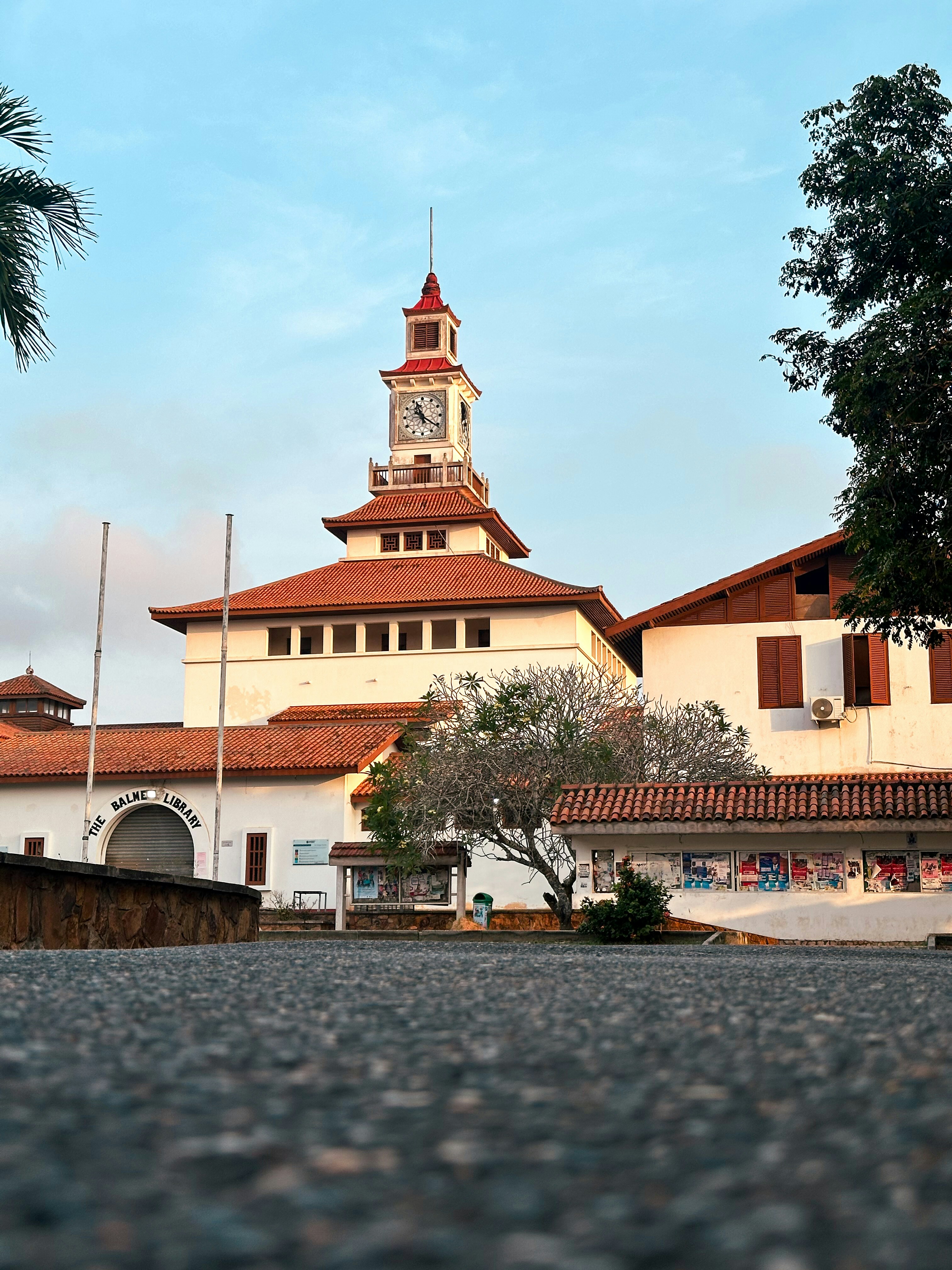Un bâtiment avec une tour d’horloge et un toit en tuiles rouges.