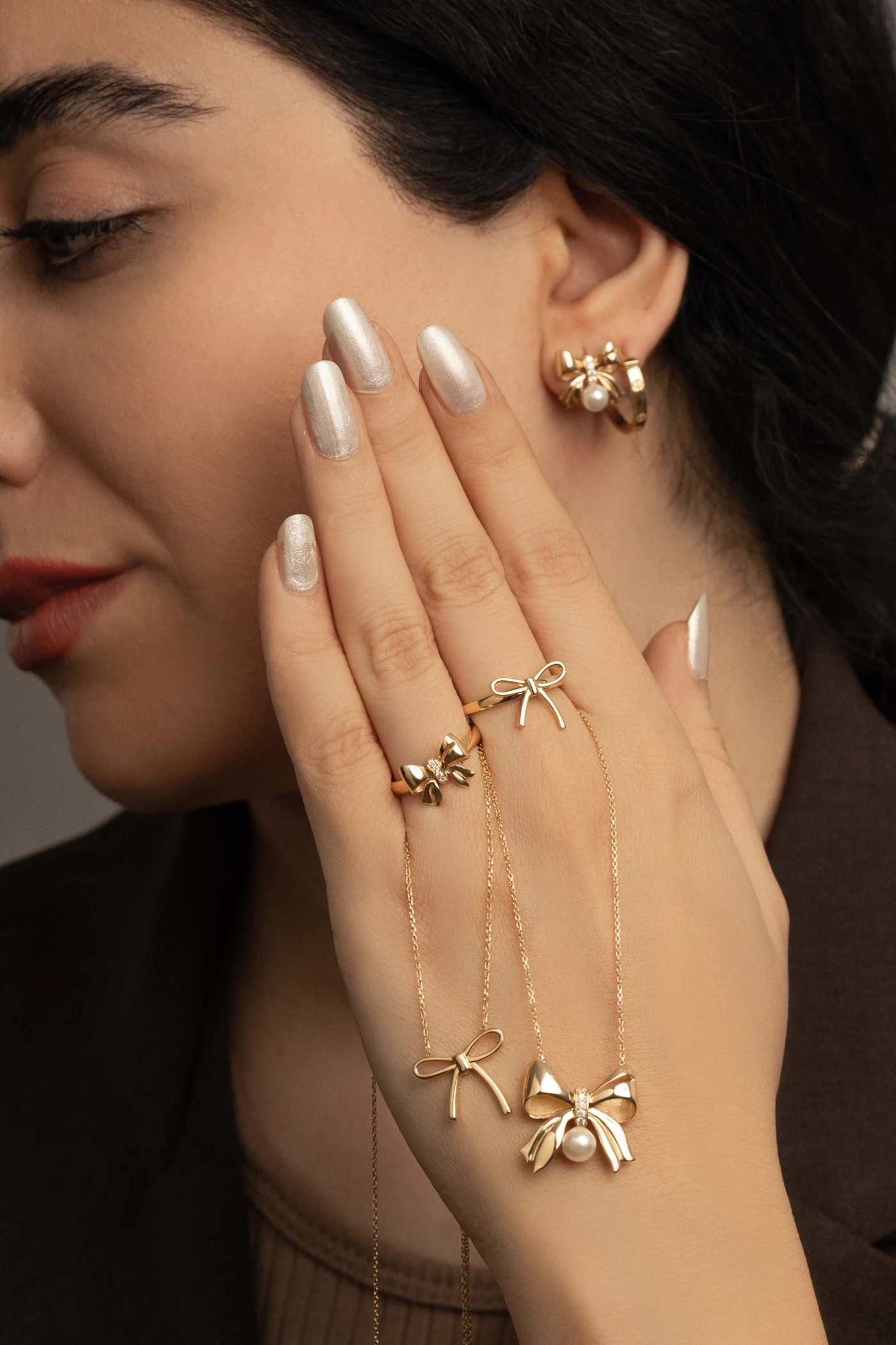 Editorial portrait with layered gold jewelry and pearl accents