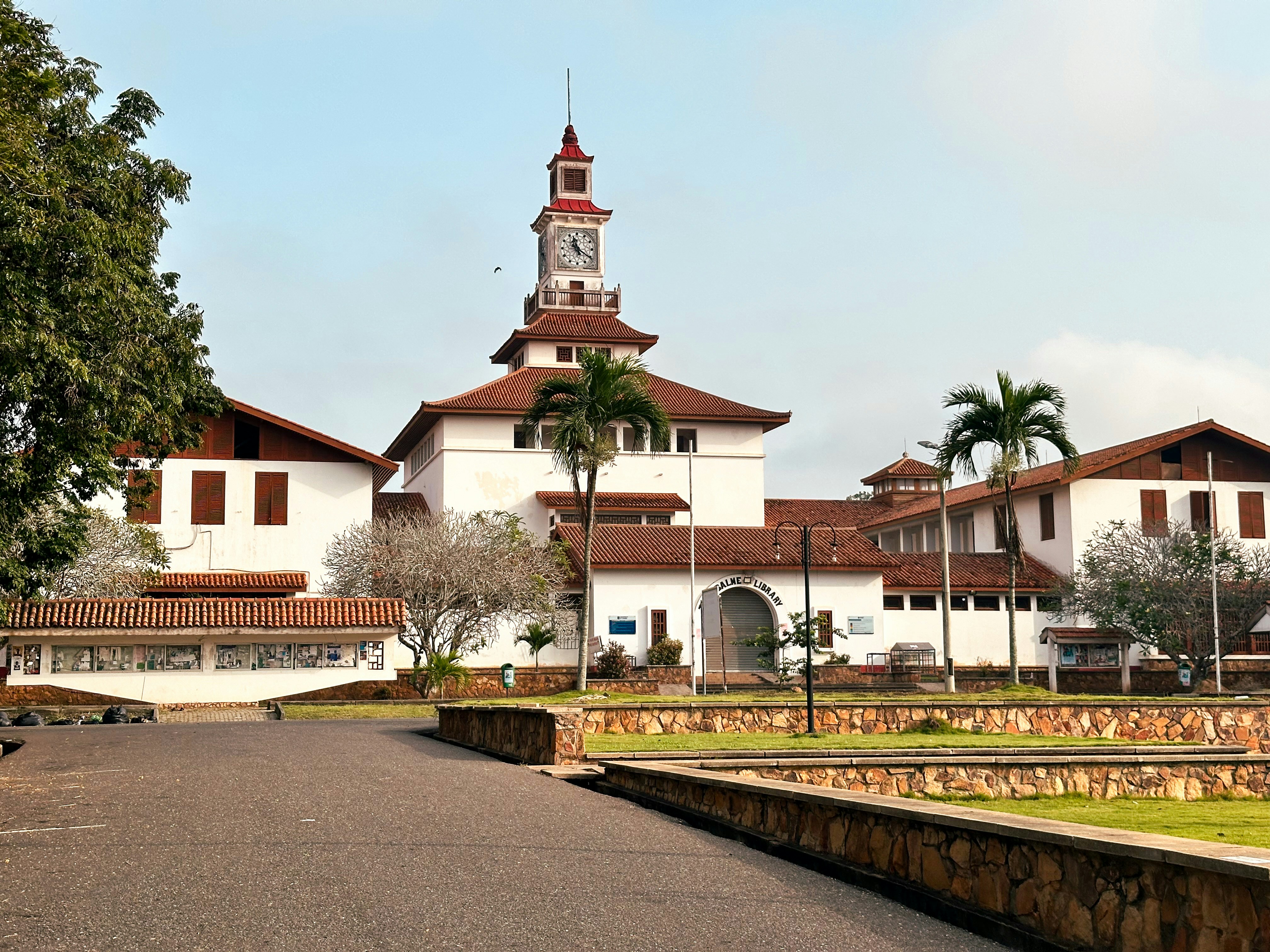 Bâtiment blanc avec une tour d’horloge et un toit rouge