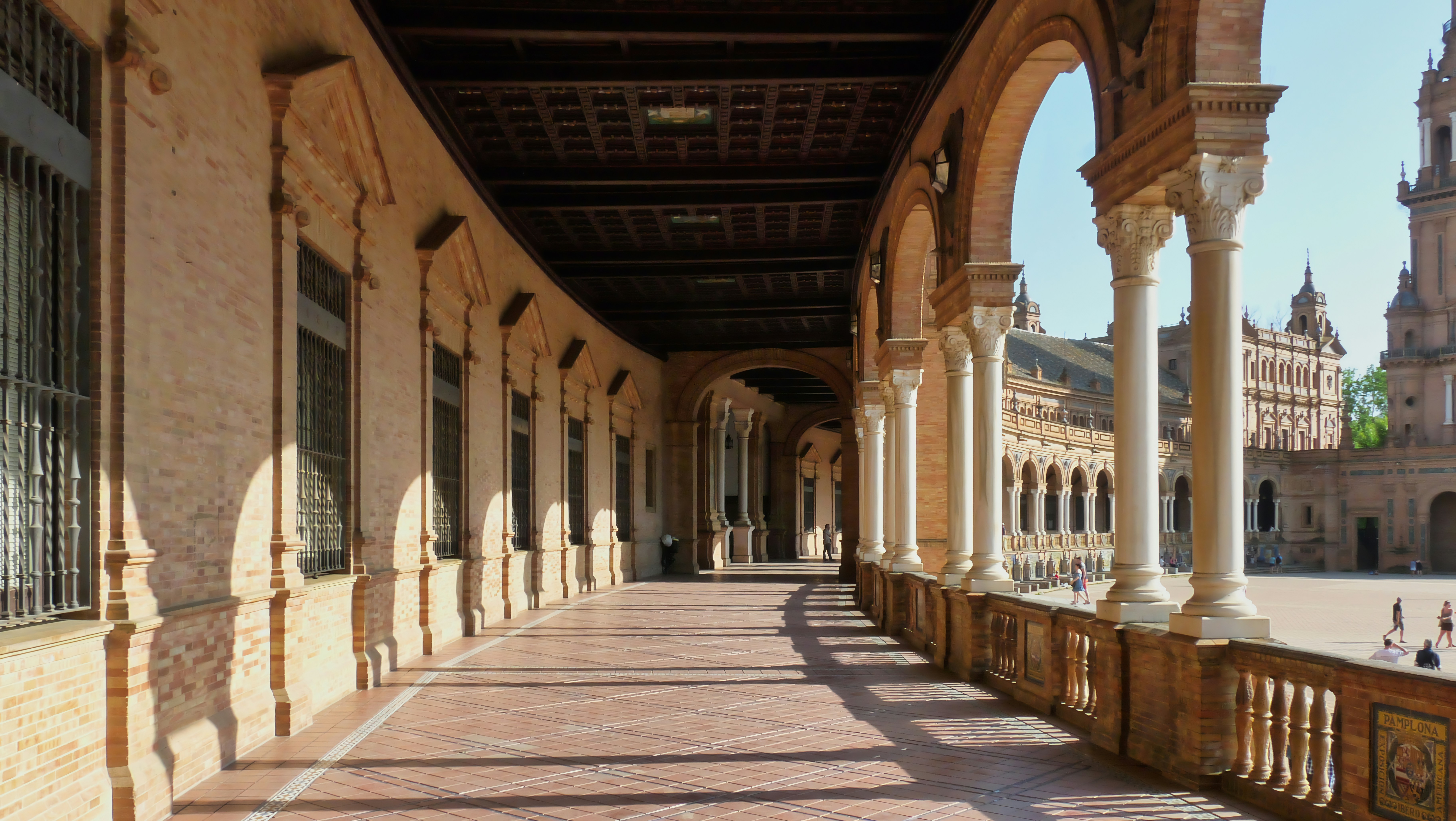 Arched walkway with ornate columns and a tiled floor.