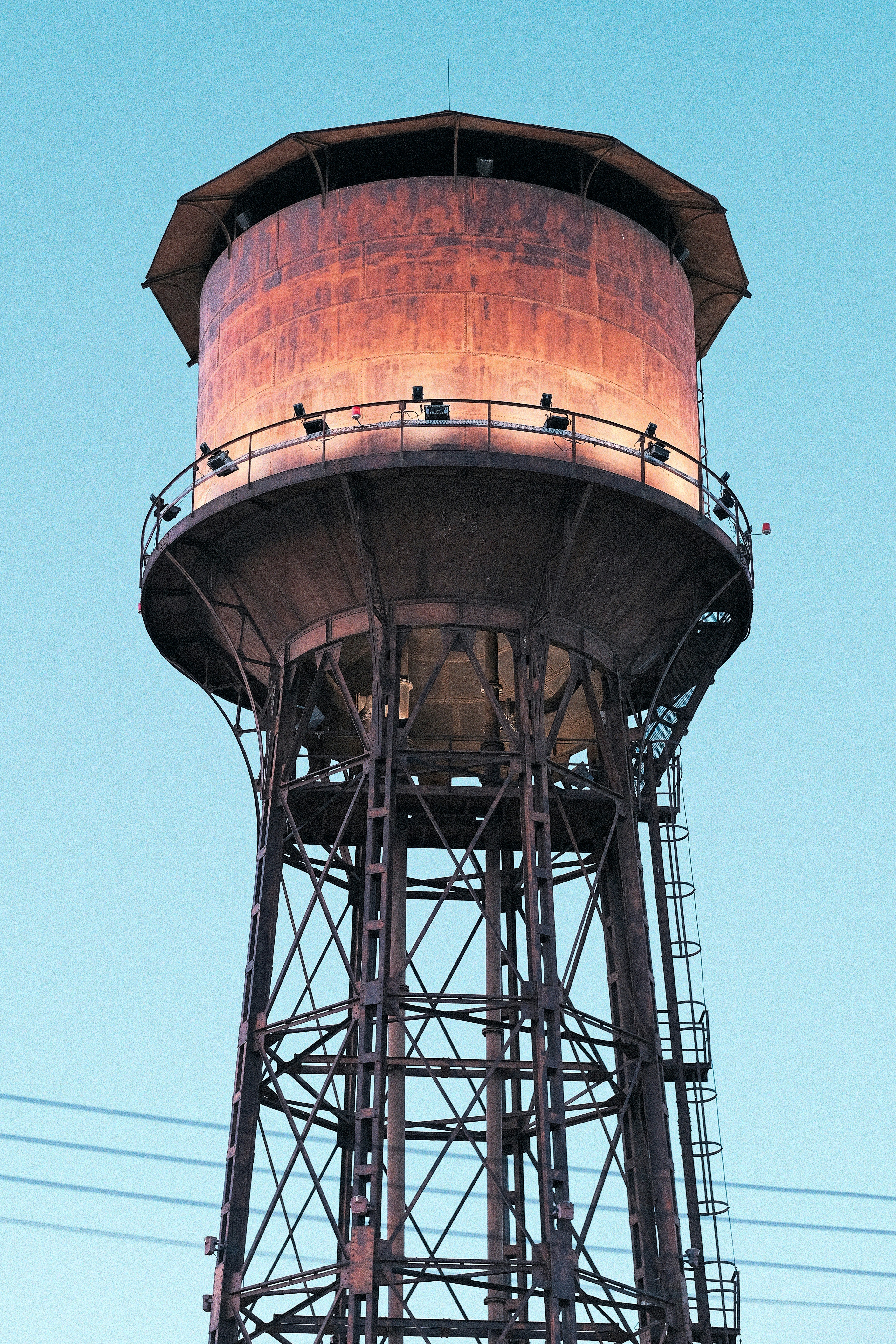 An old rusty water tower against a clear blue sky