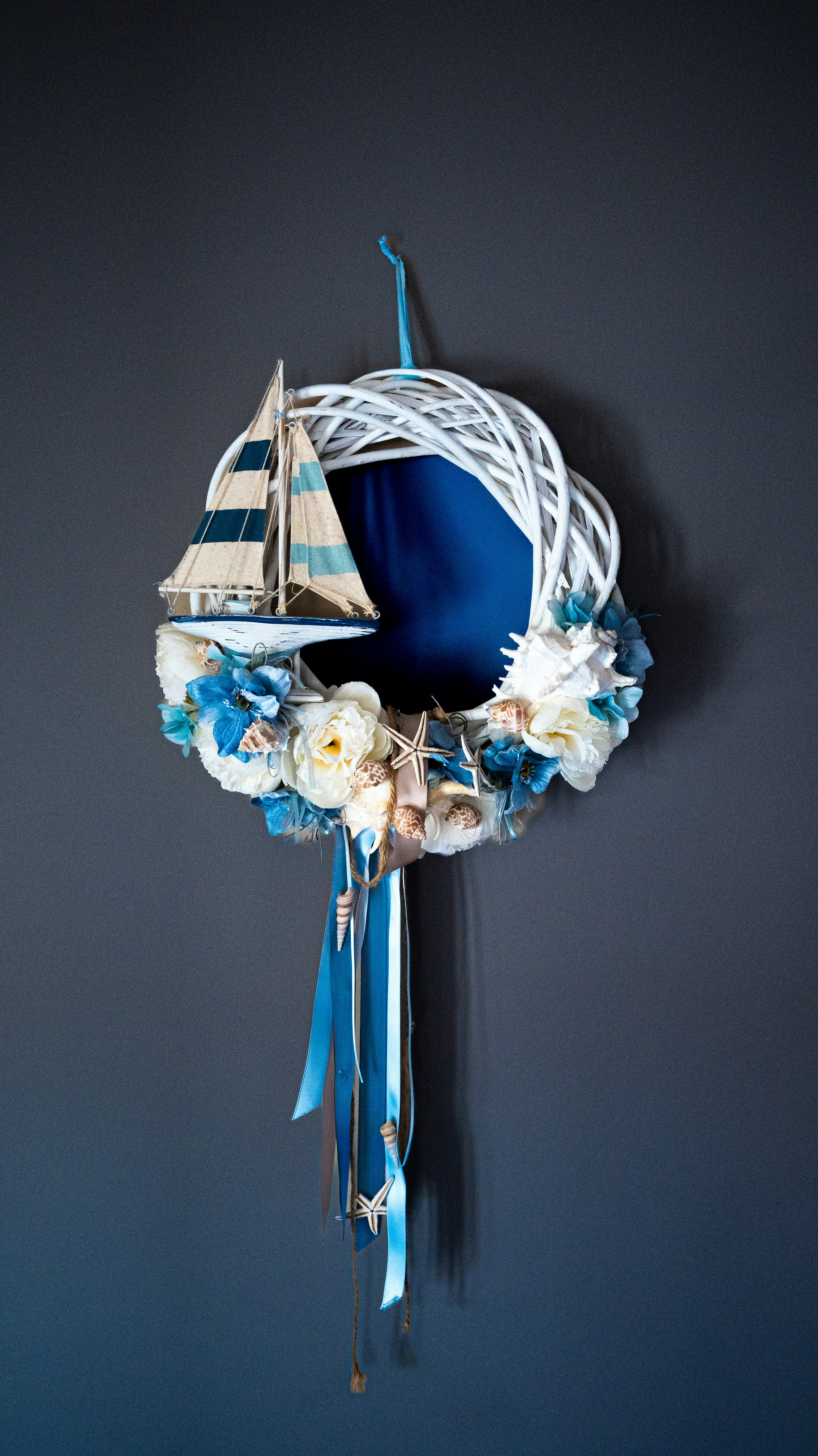 Nautical wreath with sailboat, flowers, and shells