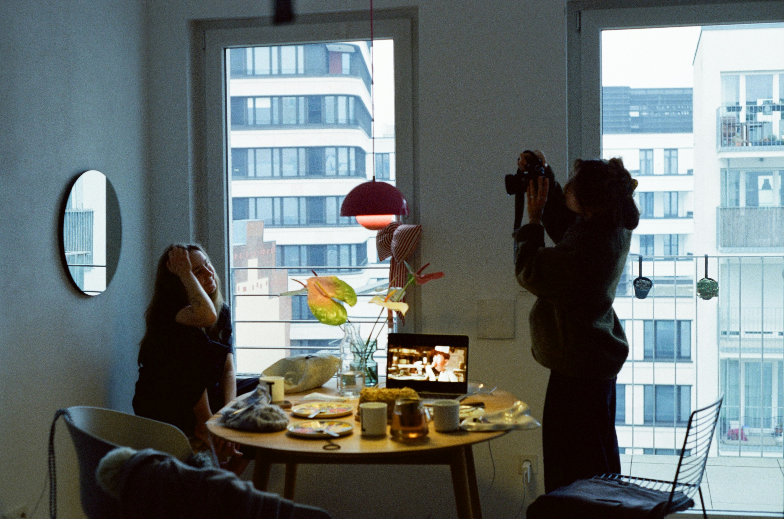 Woman taking picture of another woman indoors