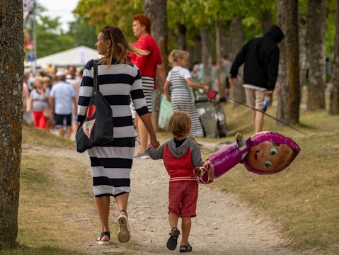 Woman and child walk with balloon on a path