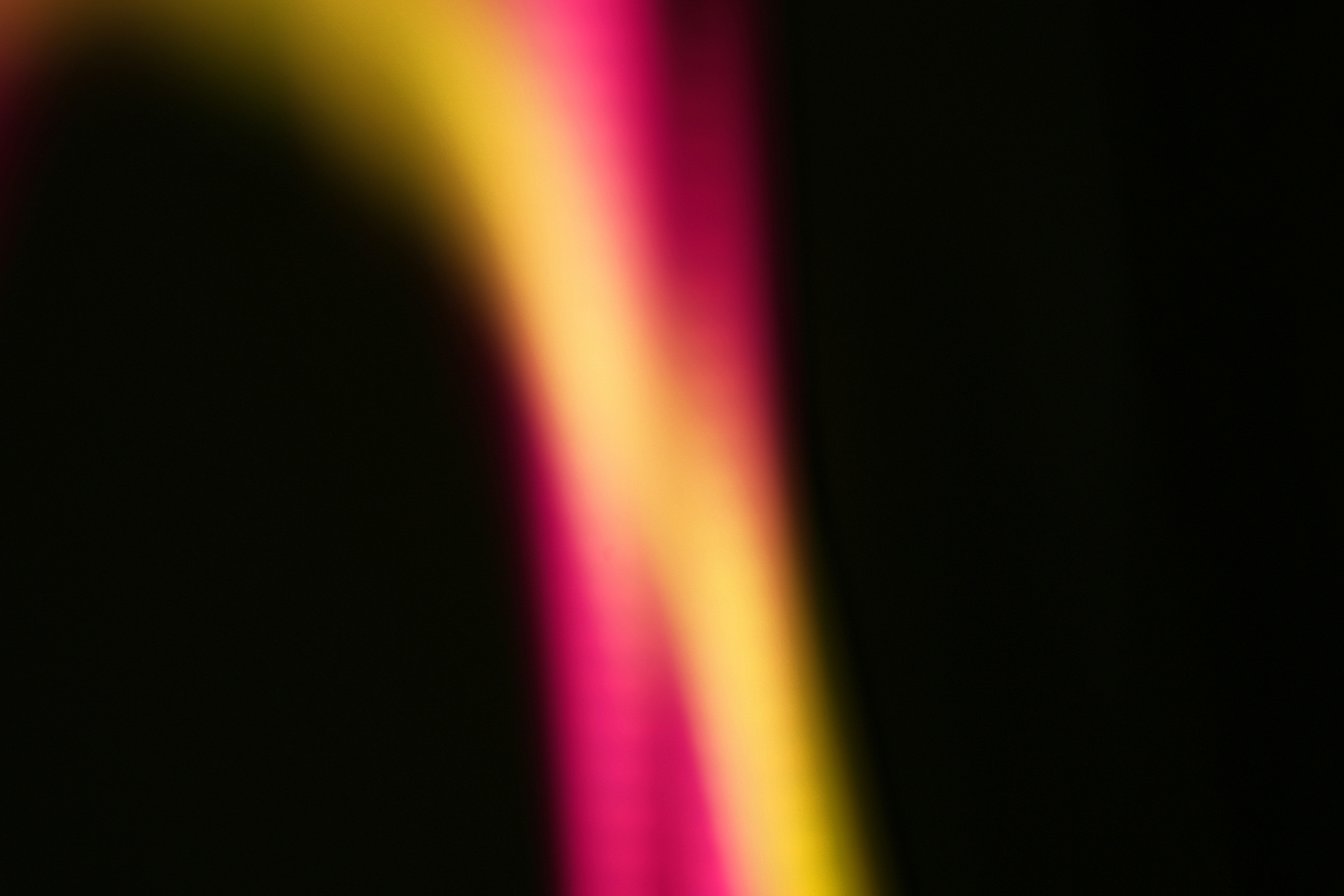 Abstract pink and yellow streaks on black background