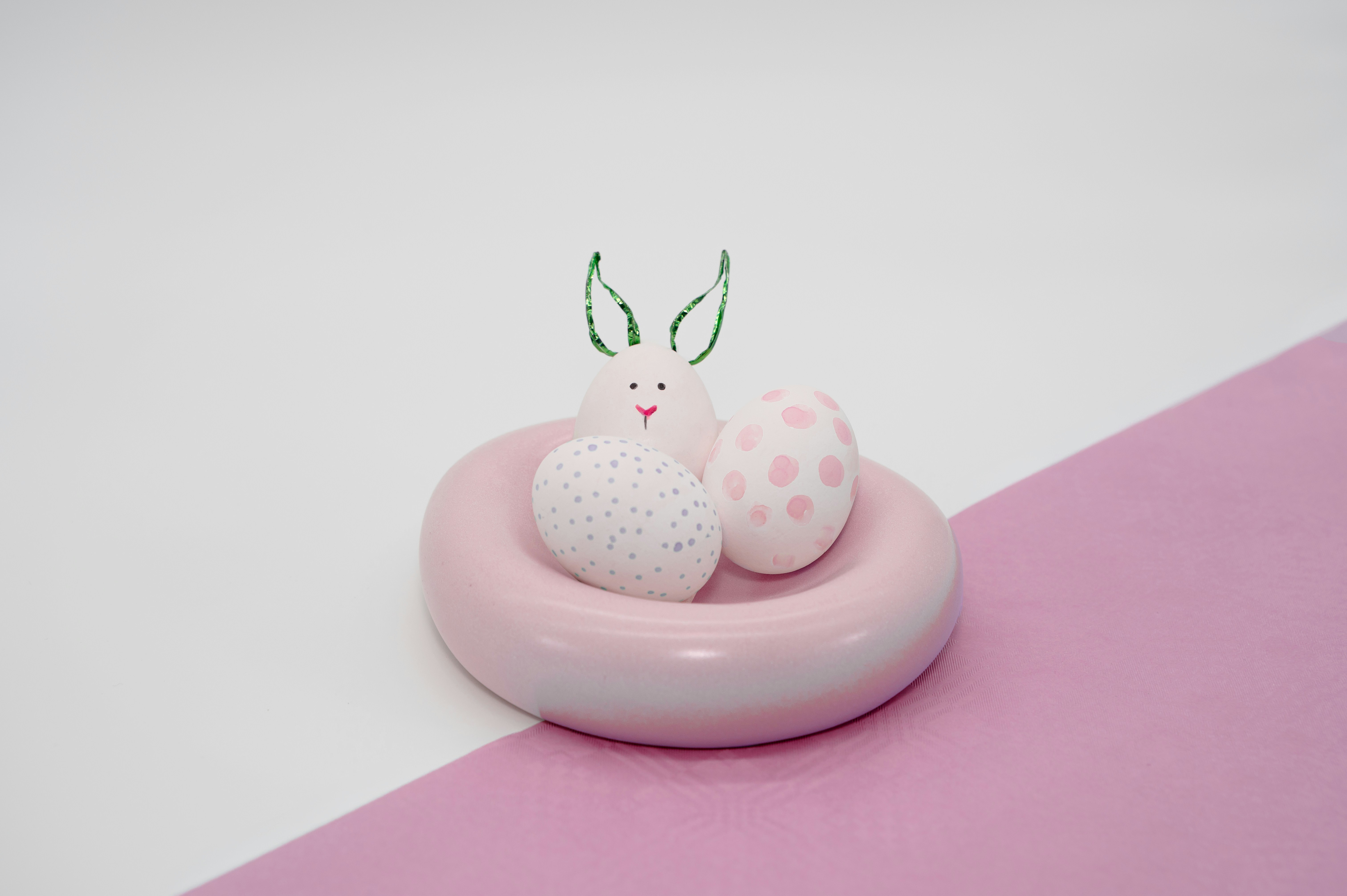 Pink ceramic ring holding bunny and two decorated eggs
