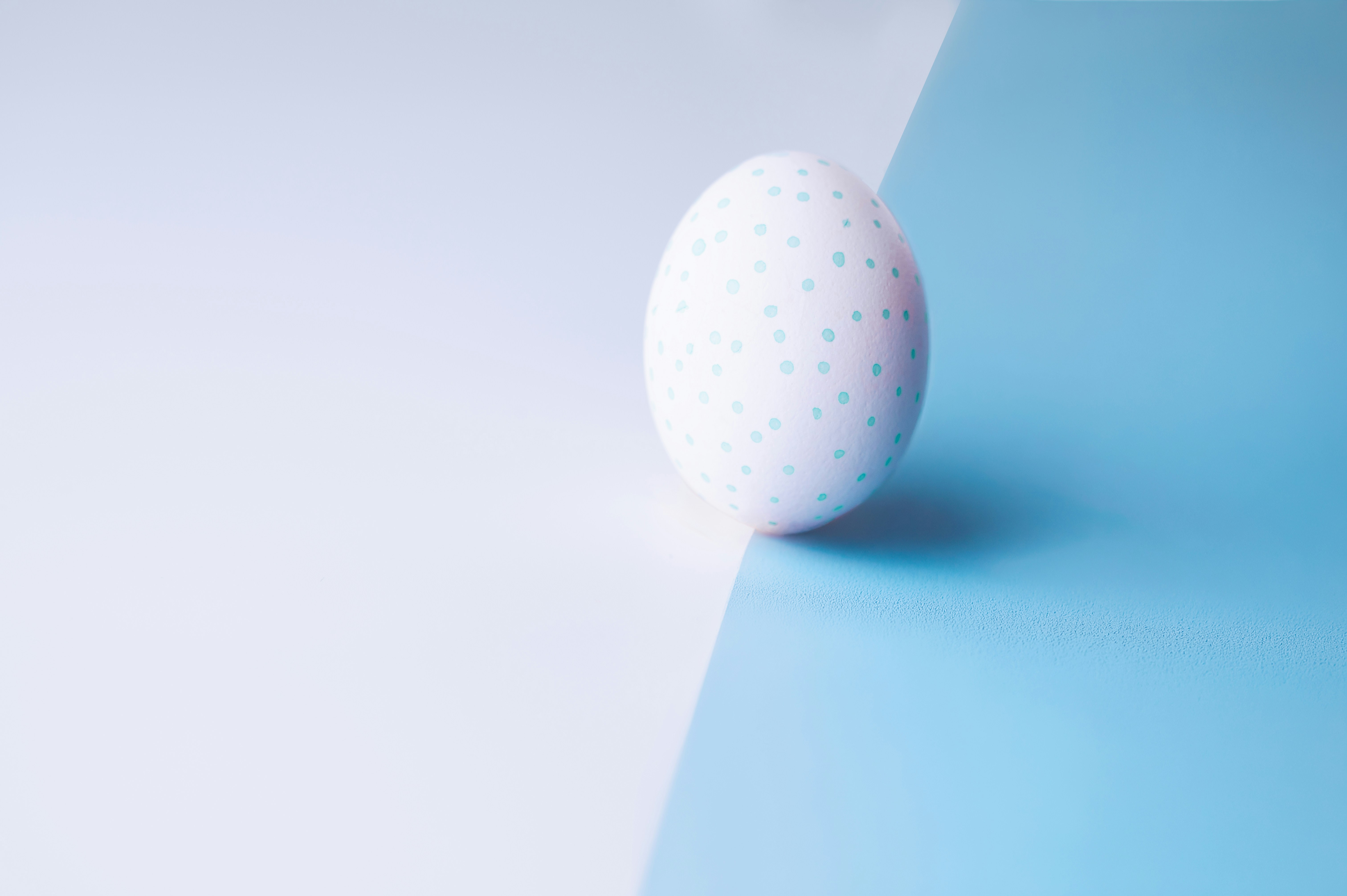 A white patterned egg on a blue and white background