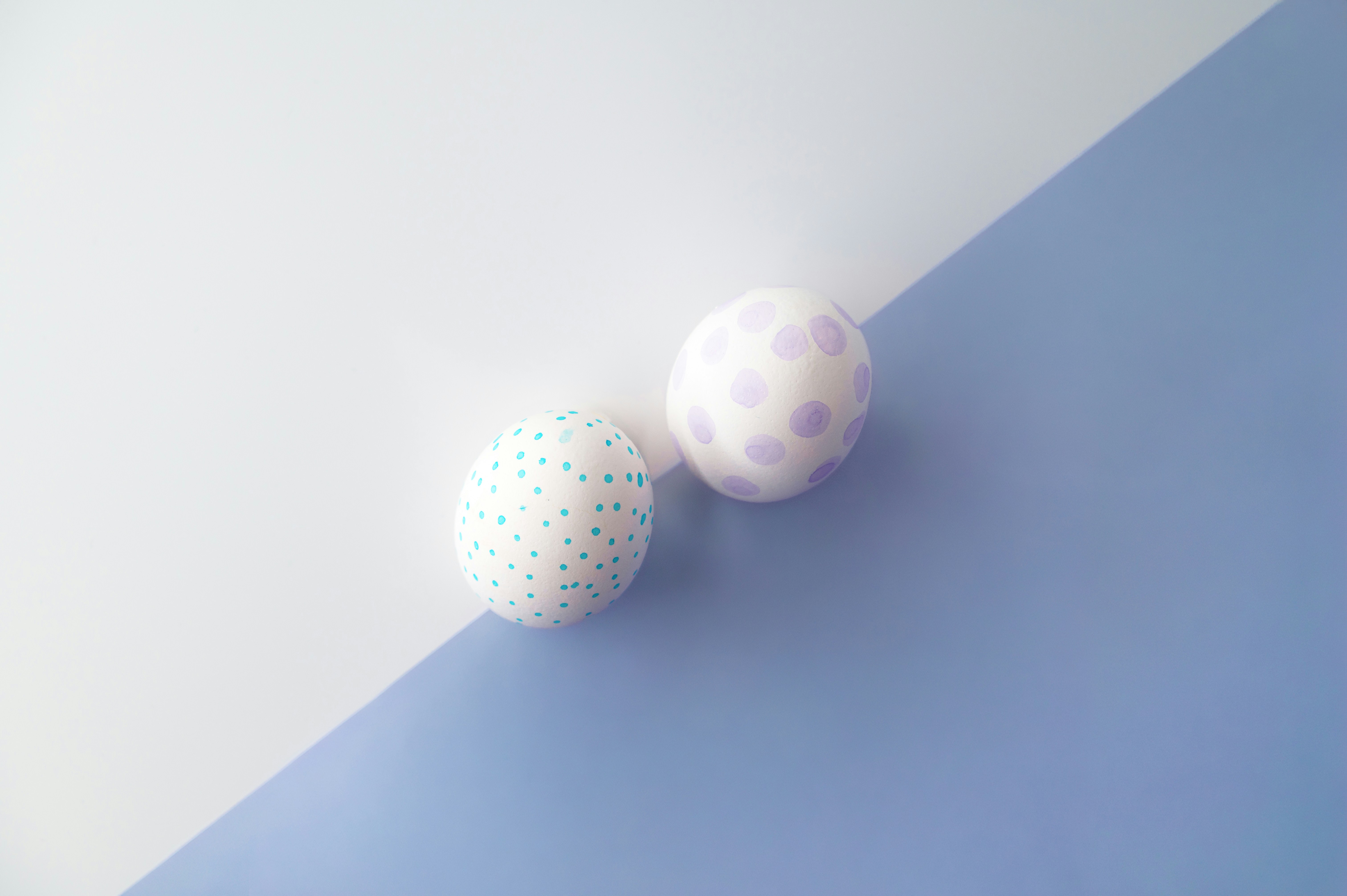 Two decorated easter eggs on a split background.