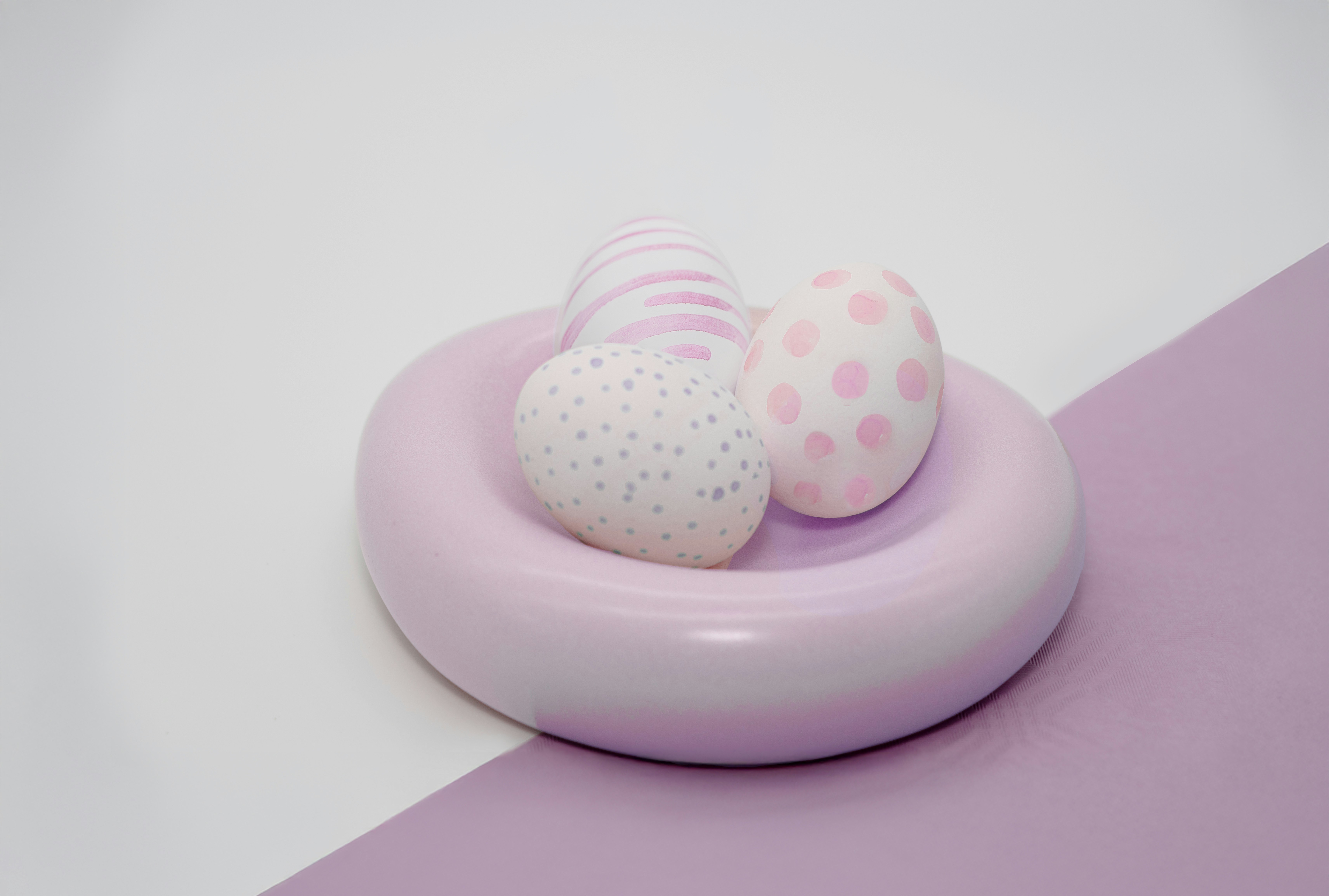 Three pastel easter eggs in a pink dish