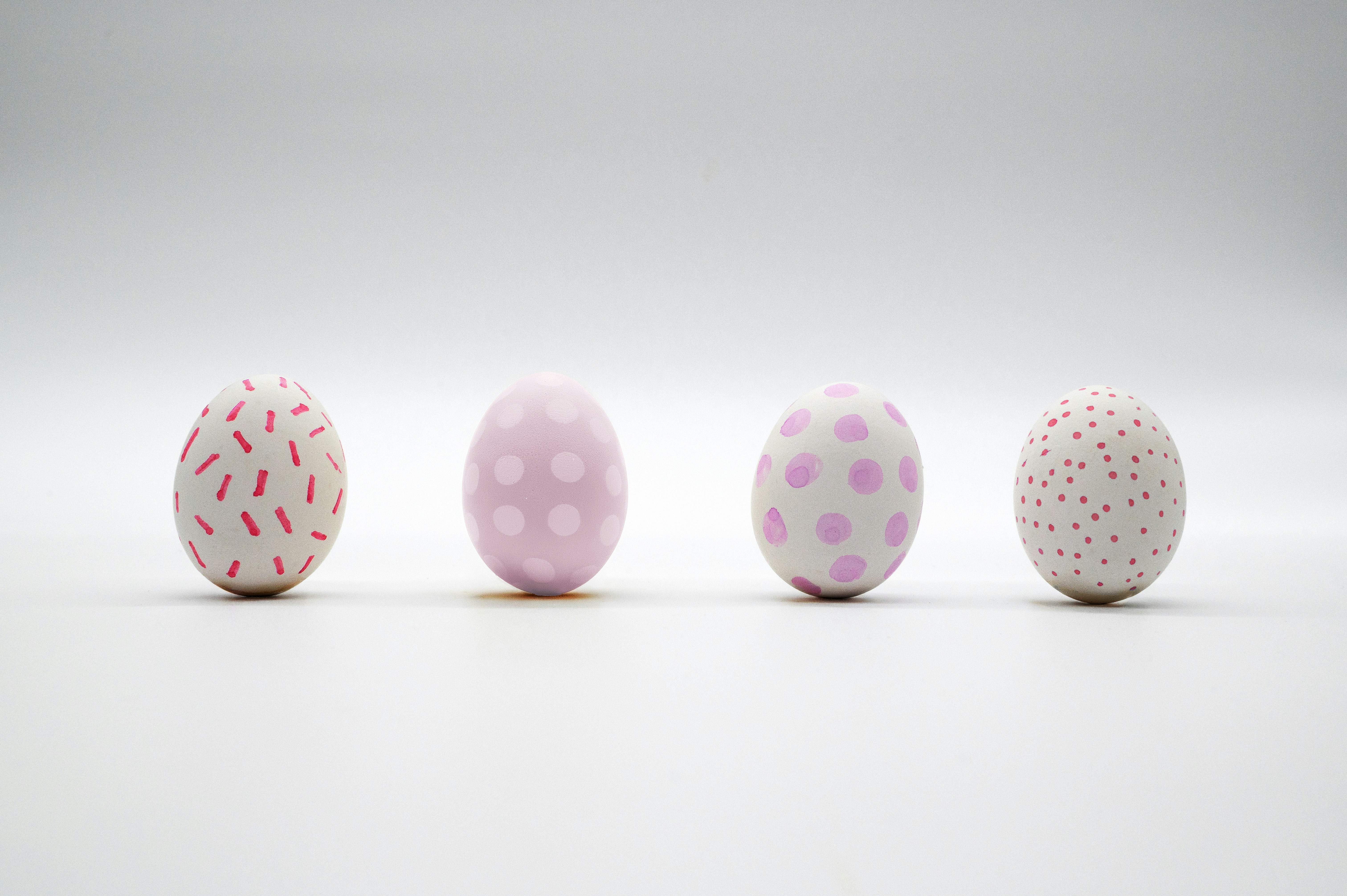 Four pastel easter eggs with patterns in a row