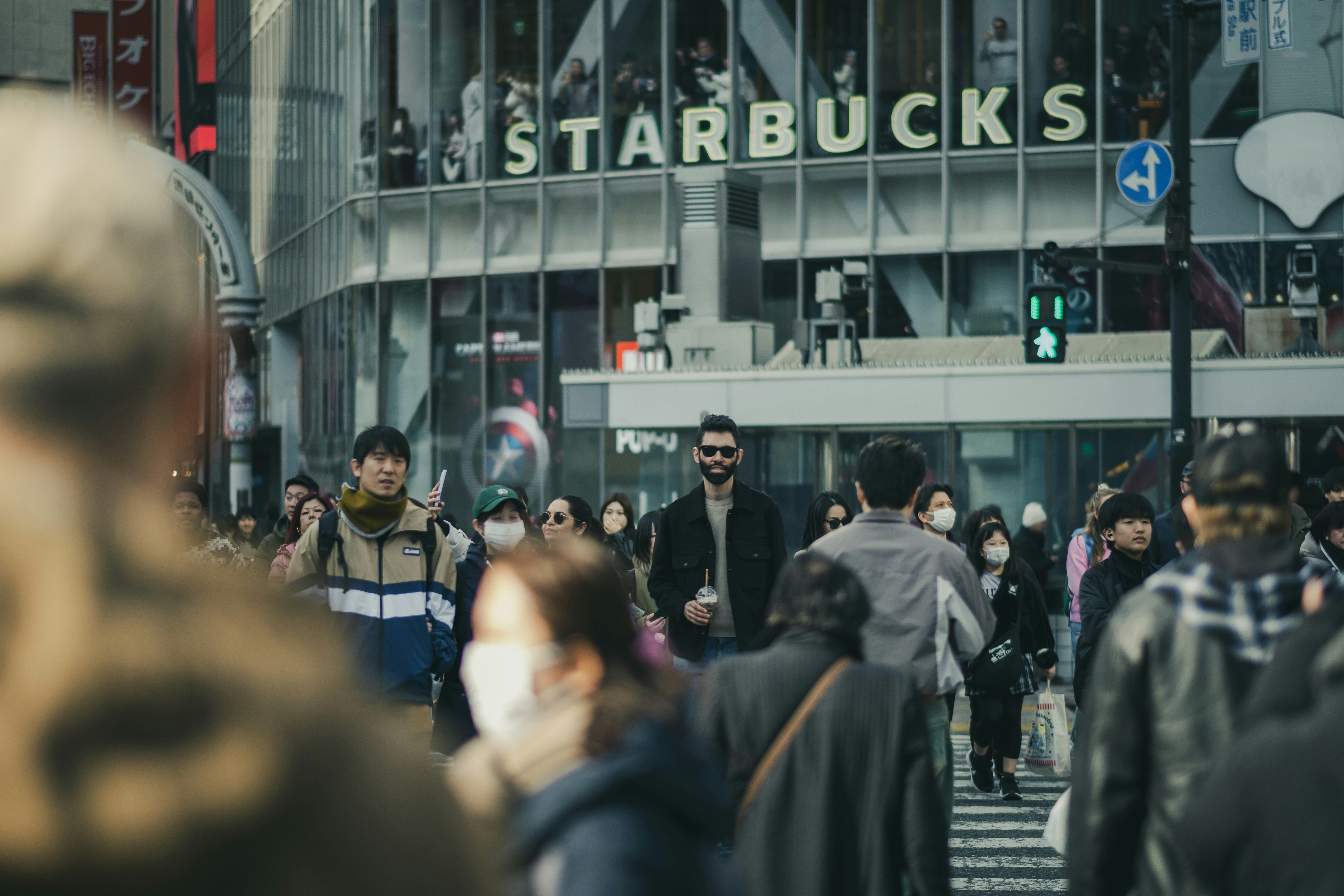 Crowded city street with starbucks sign overhead
