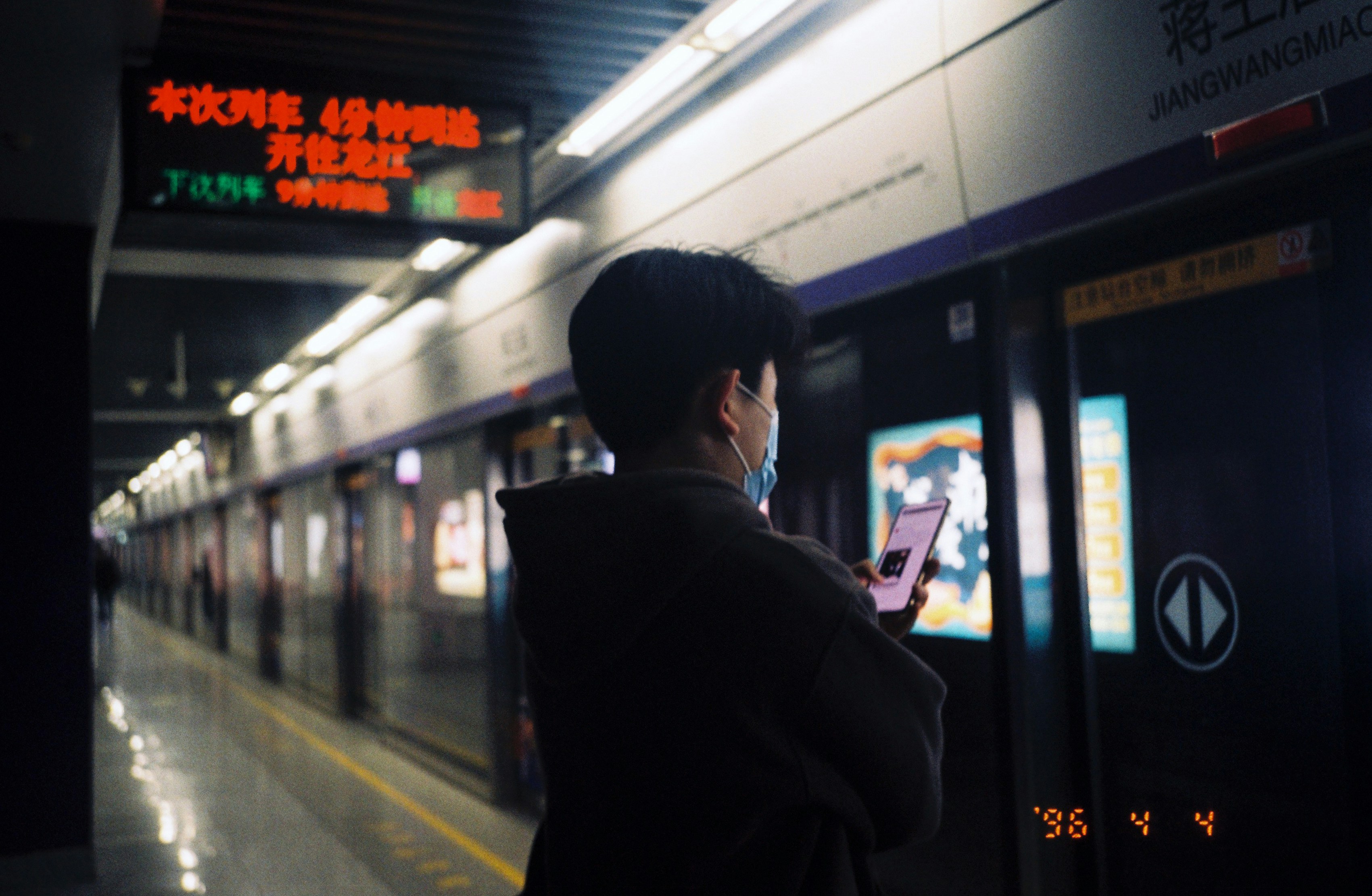 Personne regardant son téléphone sur le quai du métro