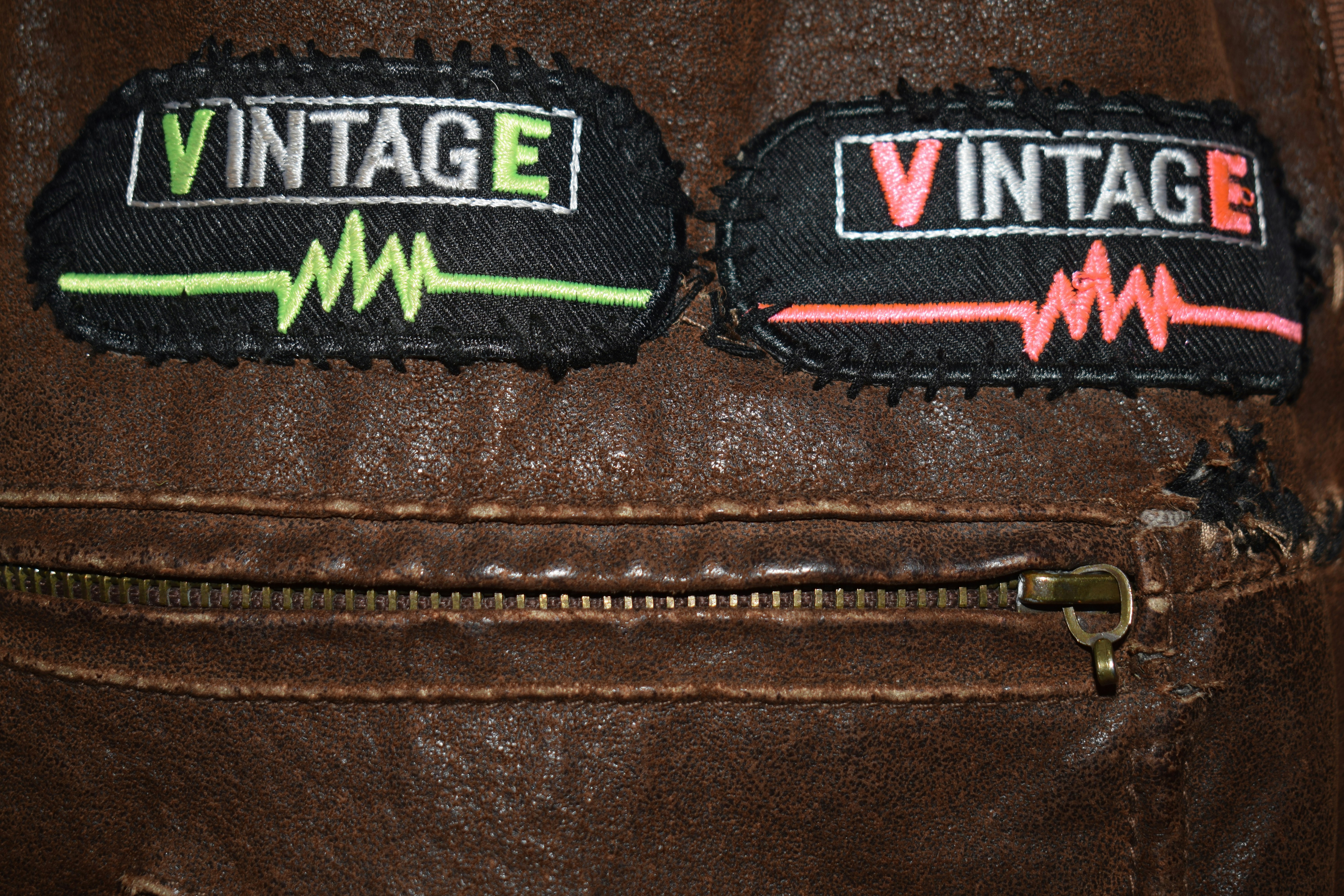 Two vintage patches on a brown leather jacket