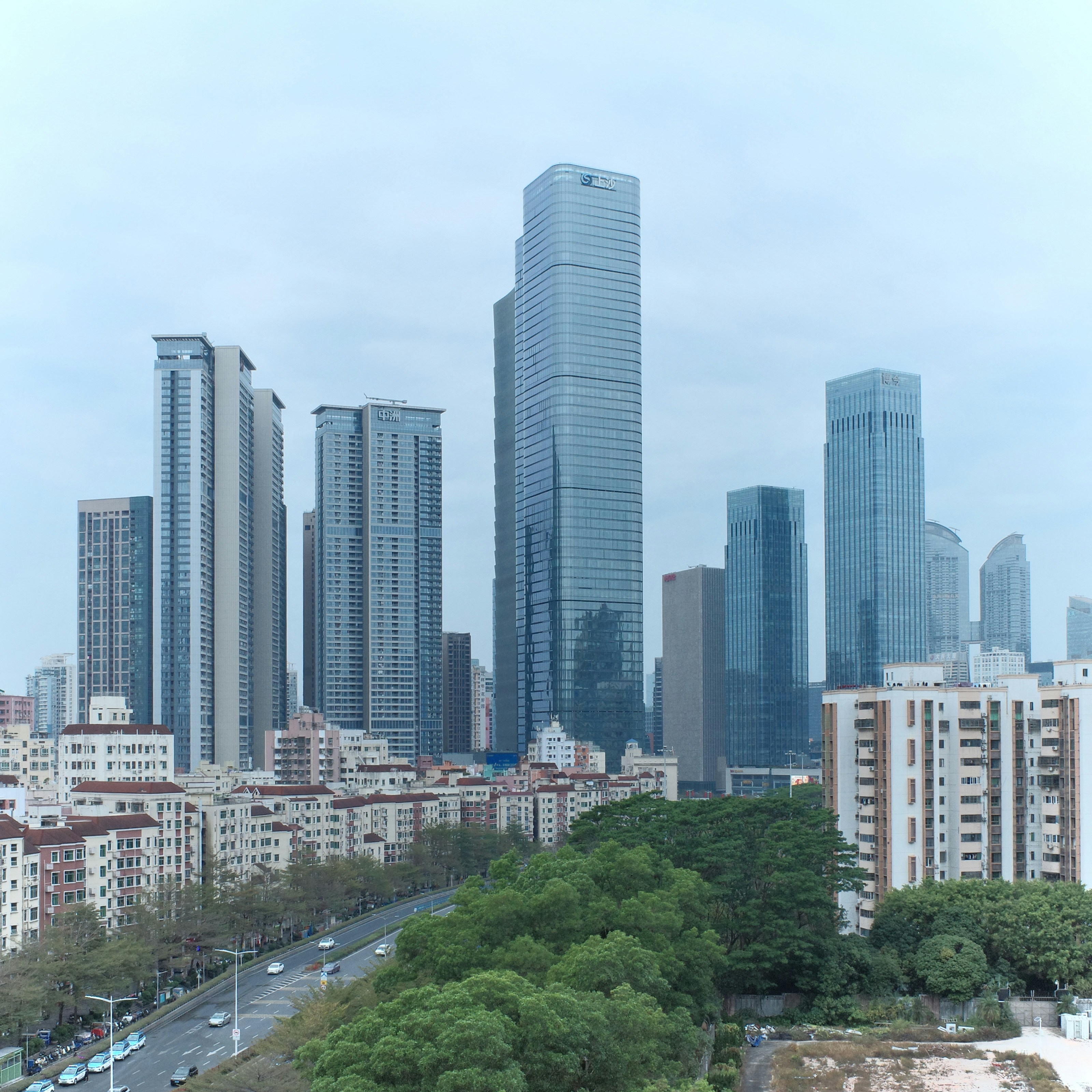 Des gratte-ciel modernes dominent la ligne d’horizon d’une ville avec des arbres.