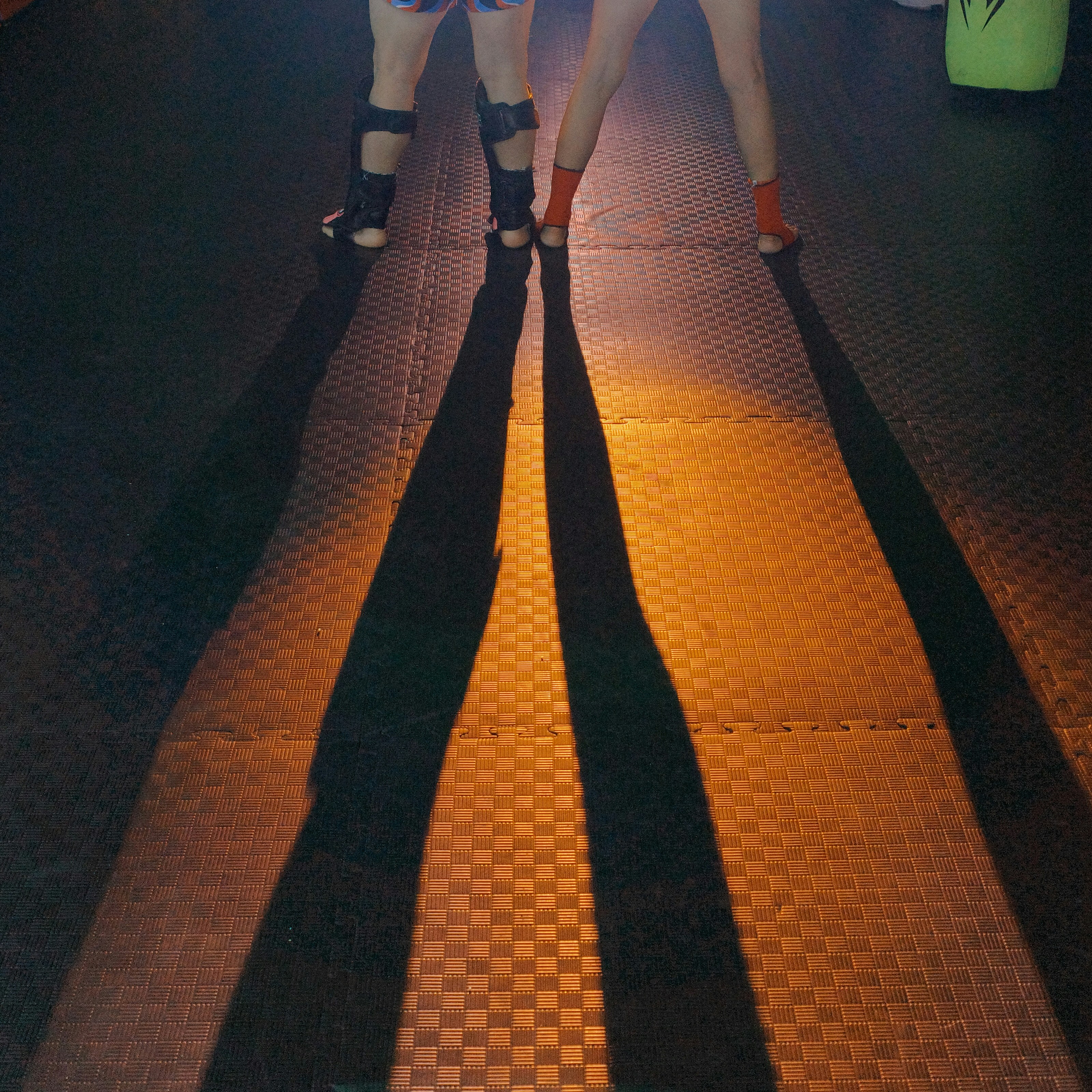 Deux jambes projetant de longues ombres sur le sol