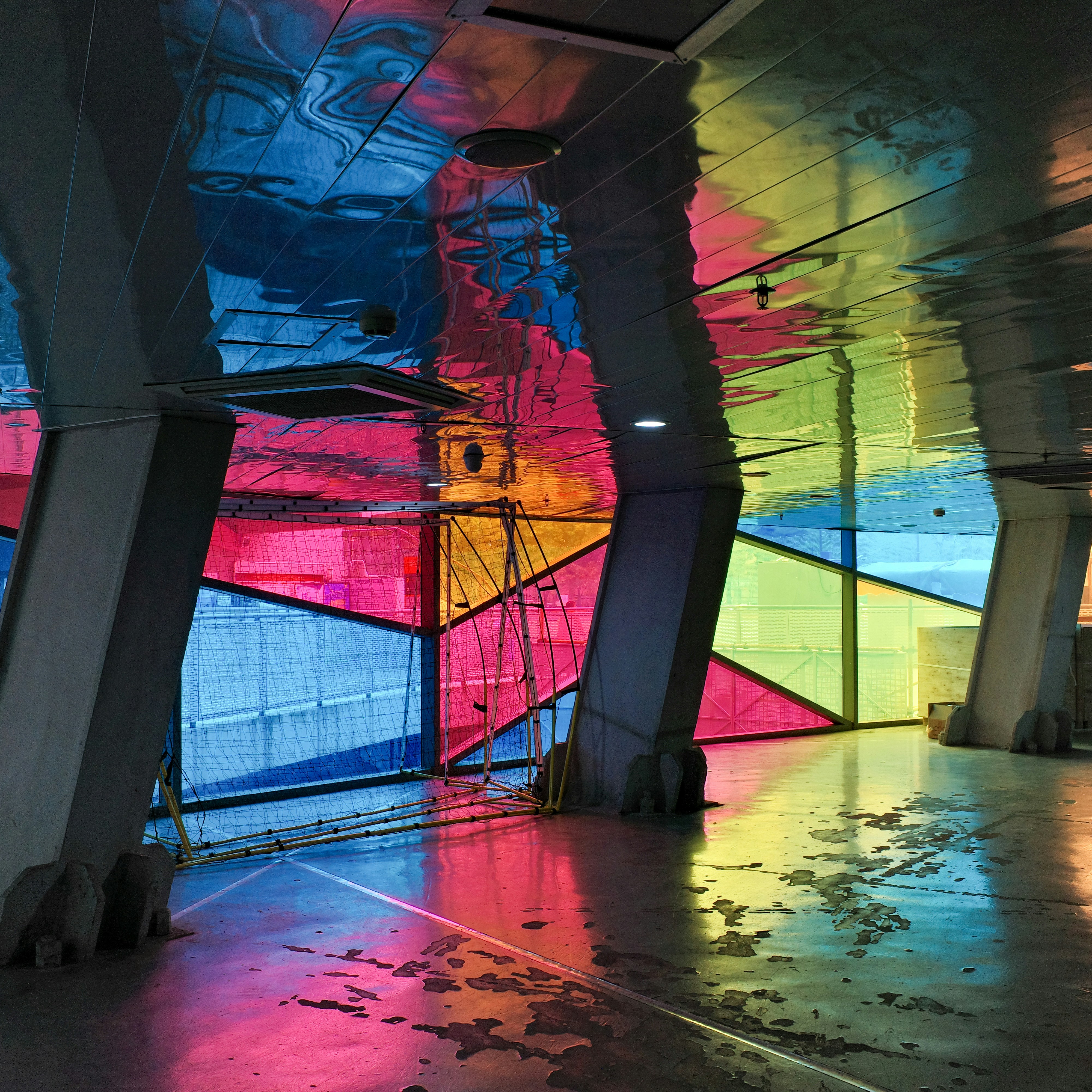 Colorful stained glass panels reflect light on floor.