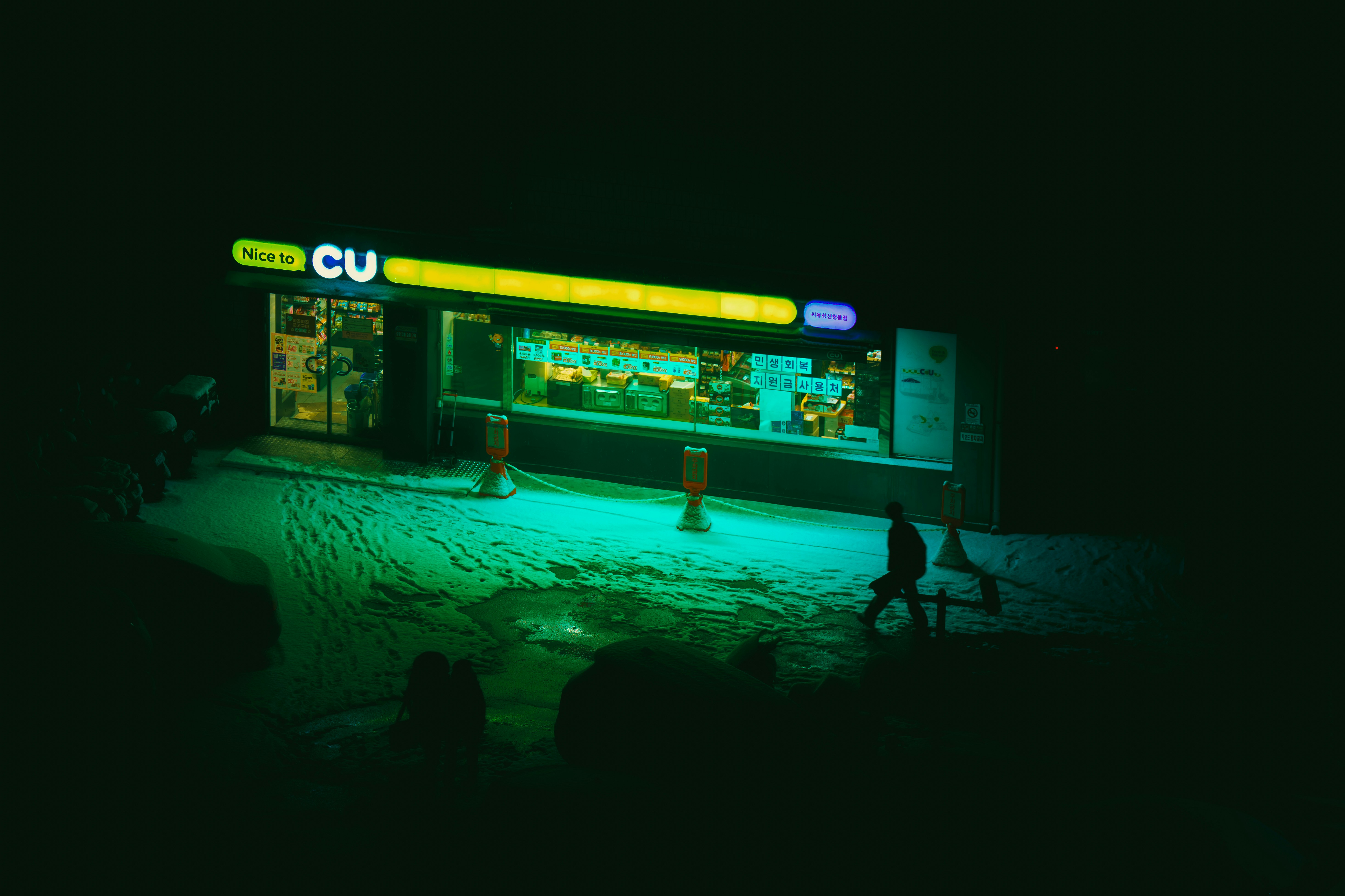 A brightly lit convenience store at night