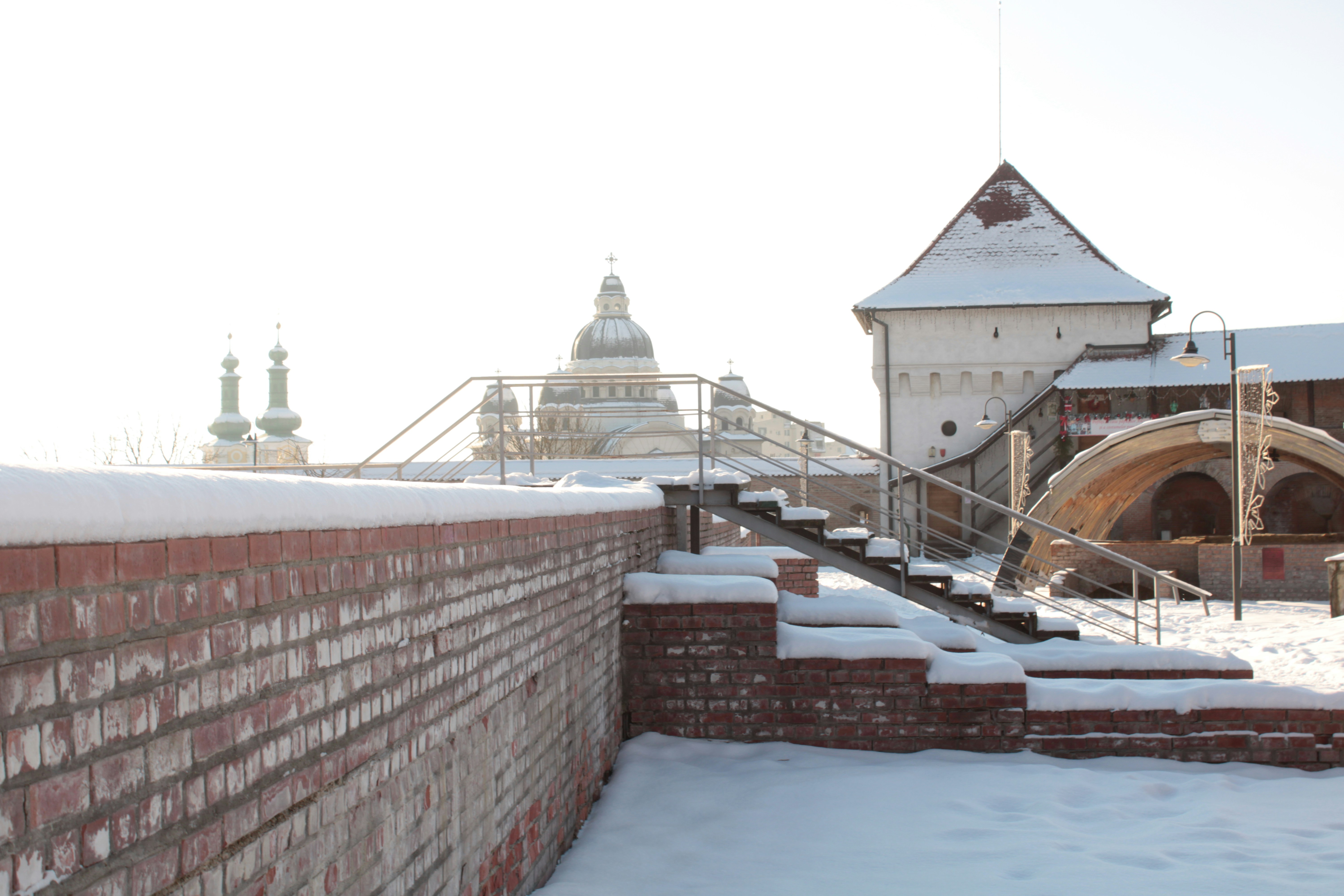Fortaleza histórica coberta de neve com cúpulas ao fundo