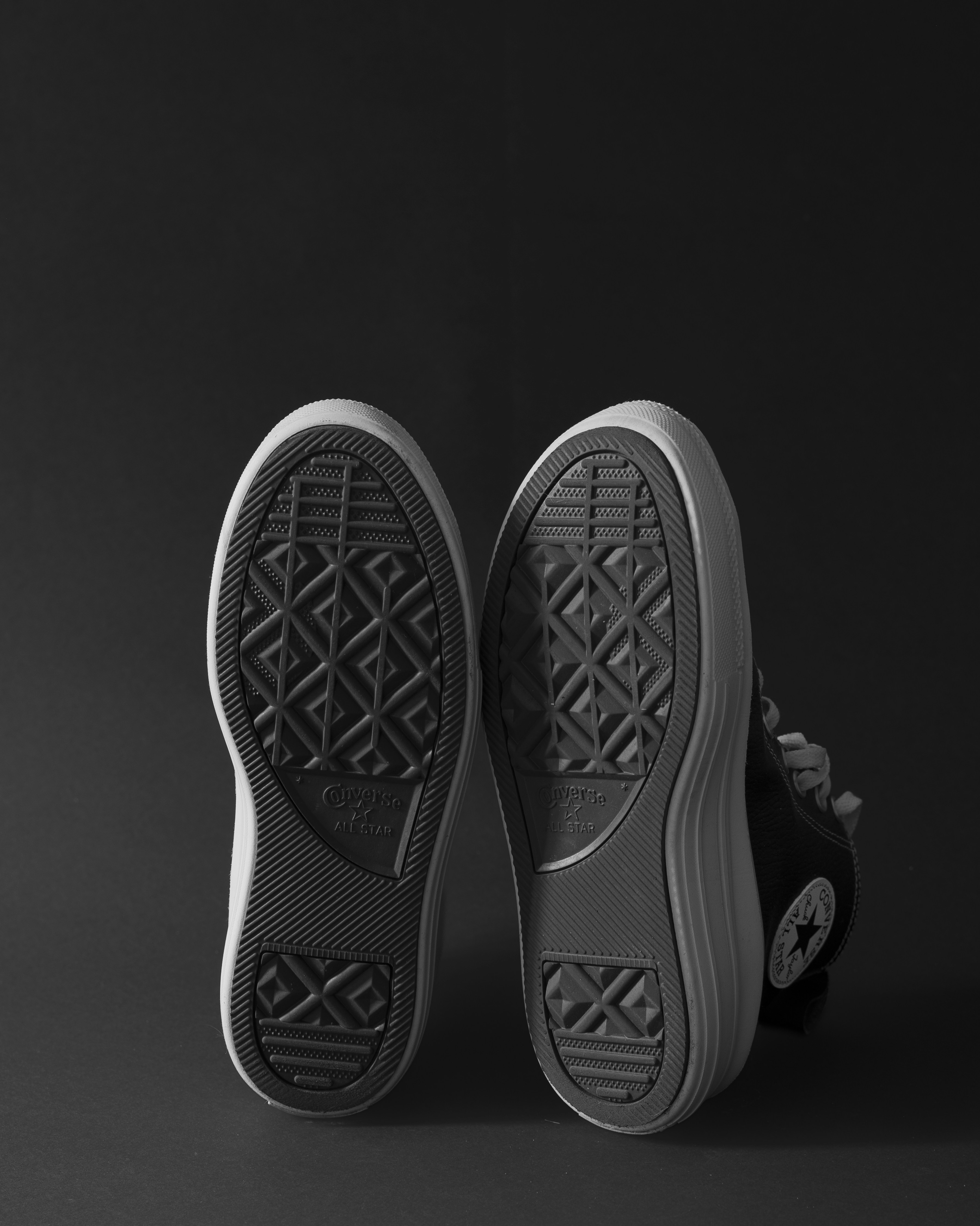 Two black high-top sneakers on a dark background