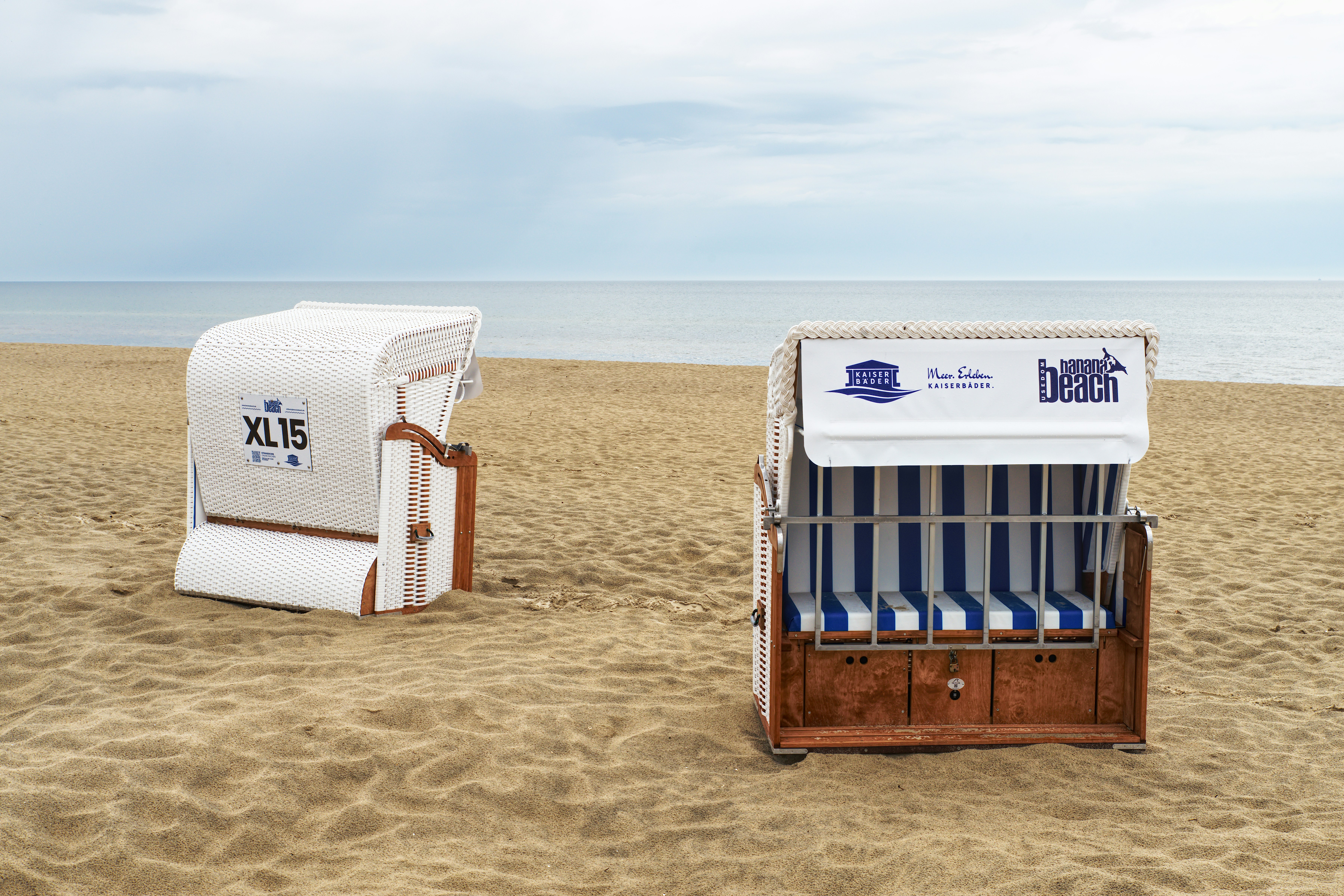 Dos sombrillas de playa en una orilla arenosa